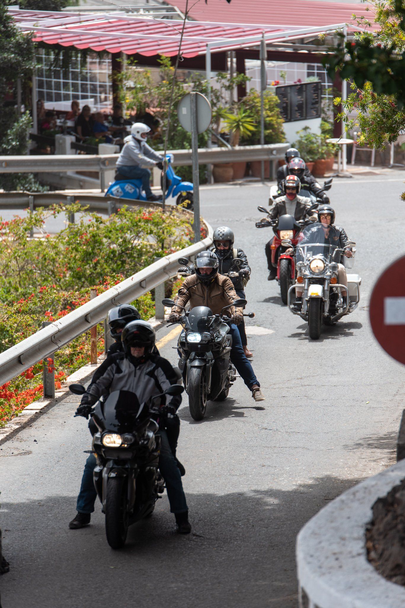 A group of people are riding motorcycles down a street