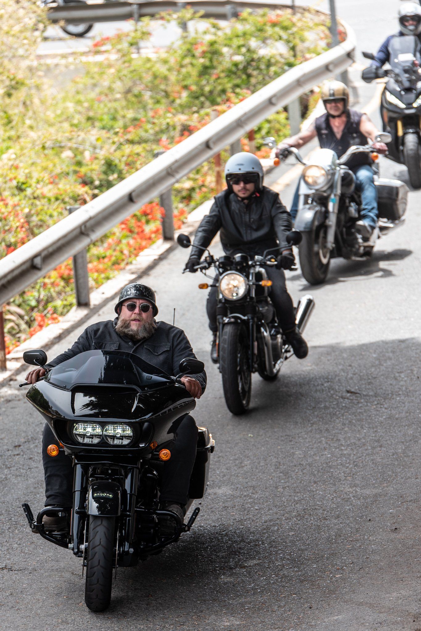 A group of people are riding motorcycles down a road.