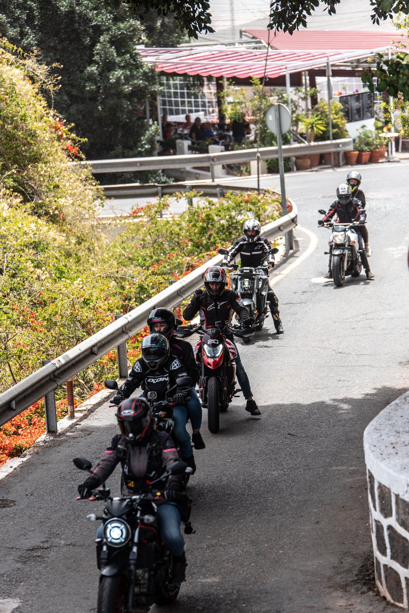 A group of people are riding motorcycles down a road.