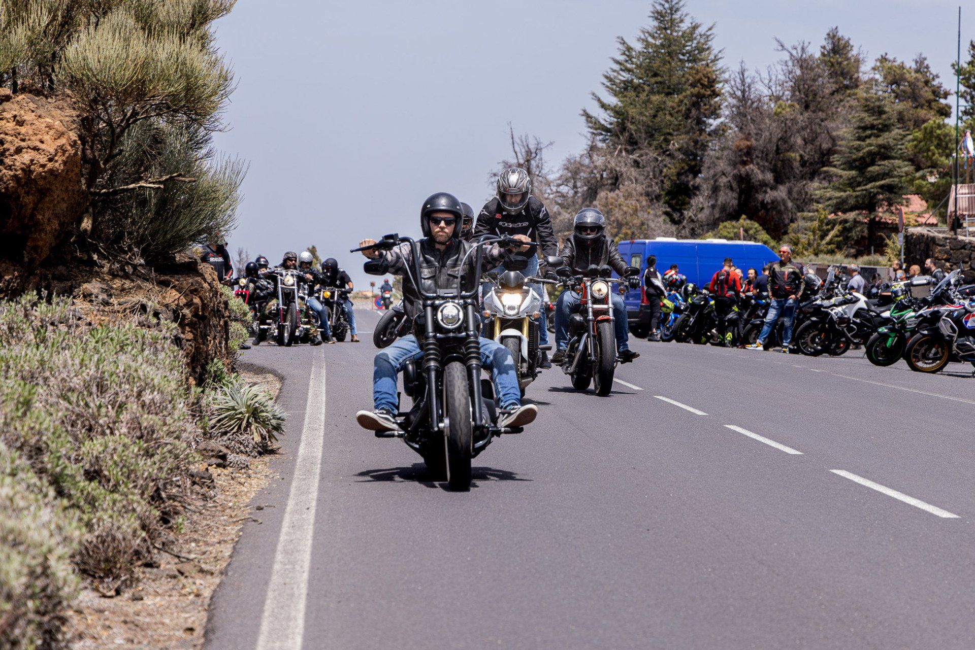 A group of people riding motorcycles down a road