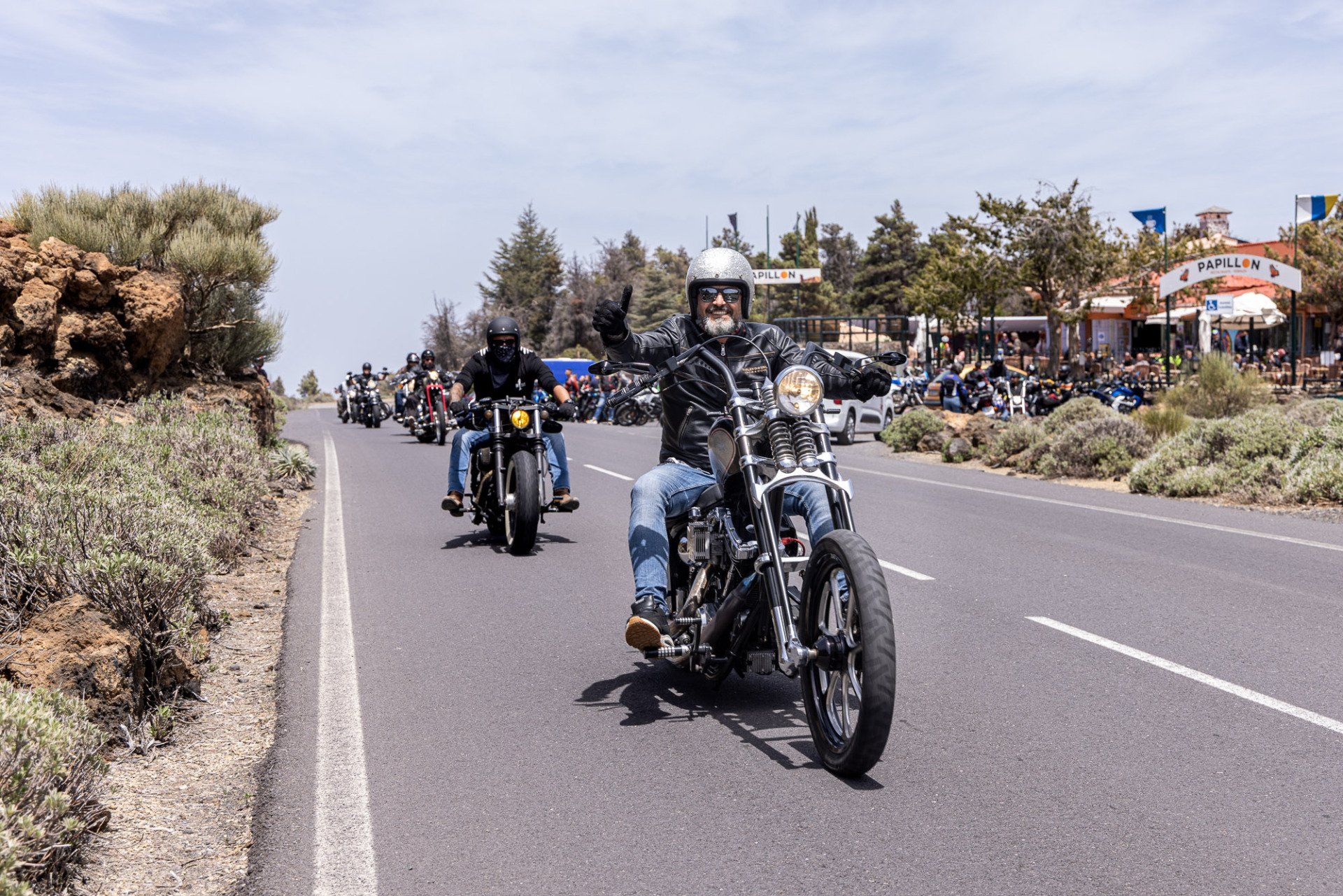A group of people are riding motorcycles down a road