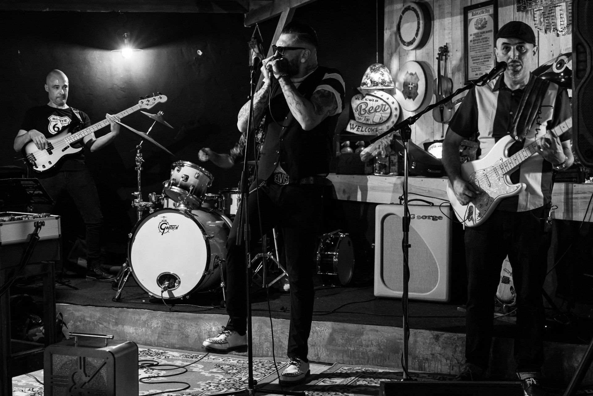 A black and white photo of a band playing instruments on stage.