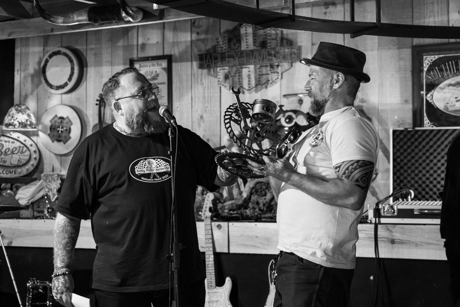 Two men are singing into microphones in a black and white photo.