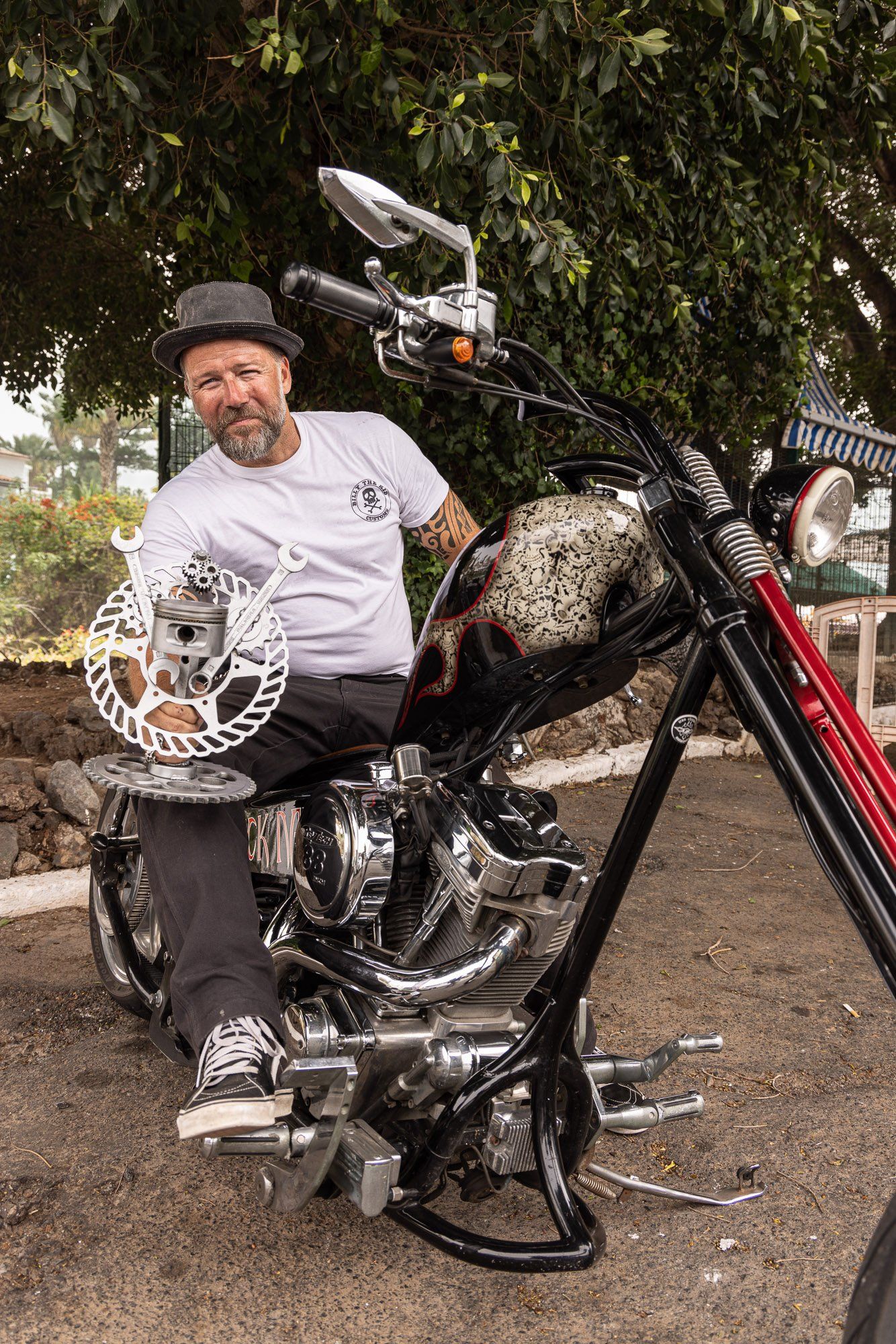 A man is sitting on a motorcycle holding a helmet.