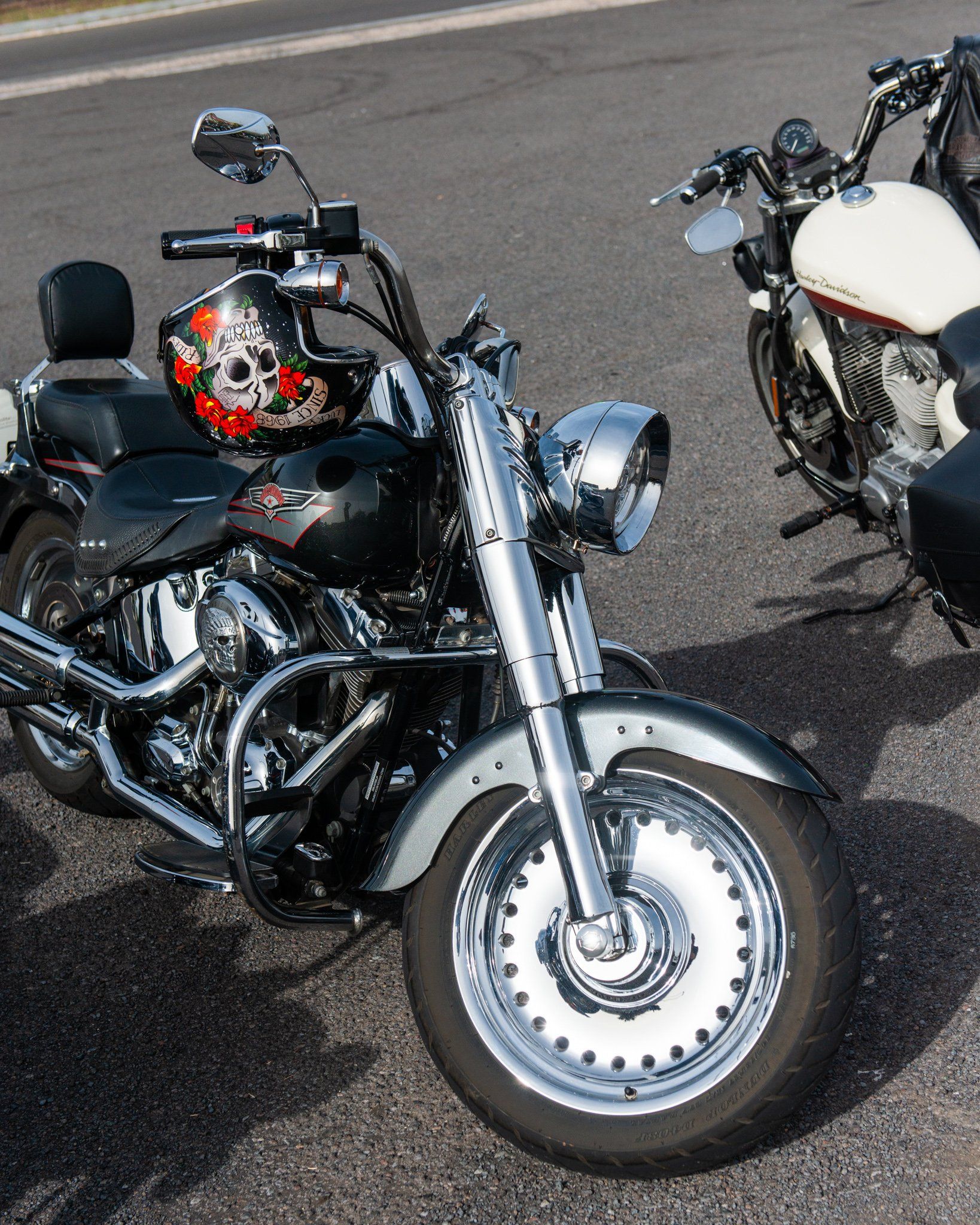 Two motorcycles are parked on the side of the road