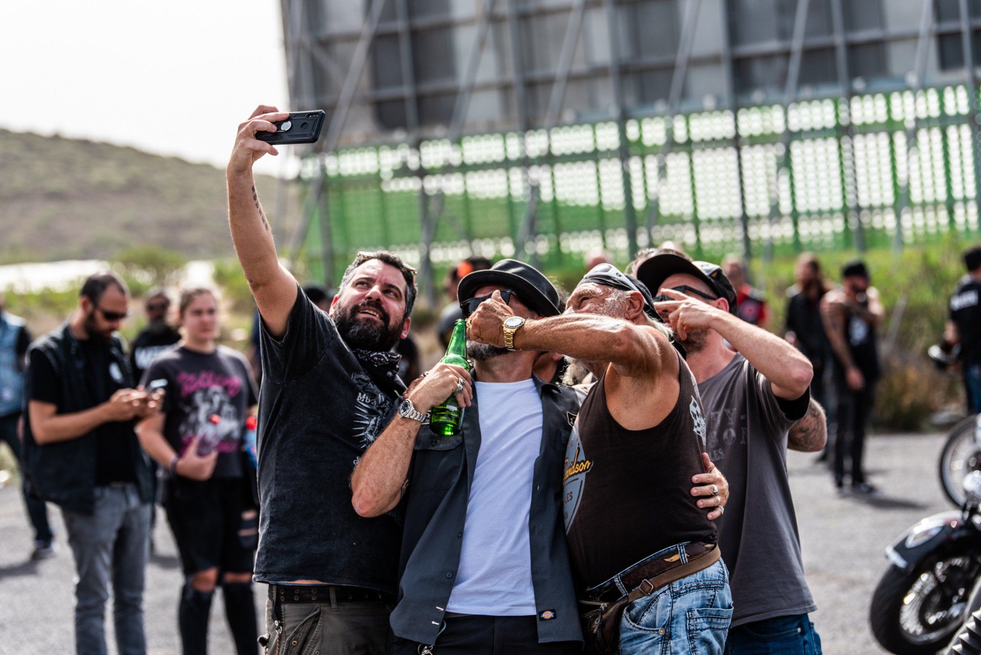 A group of men are taking a selfie with their cell phones.