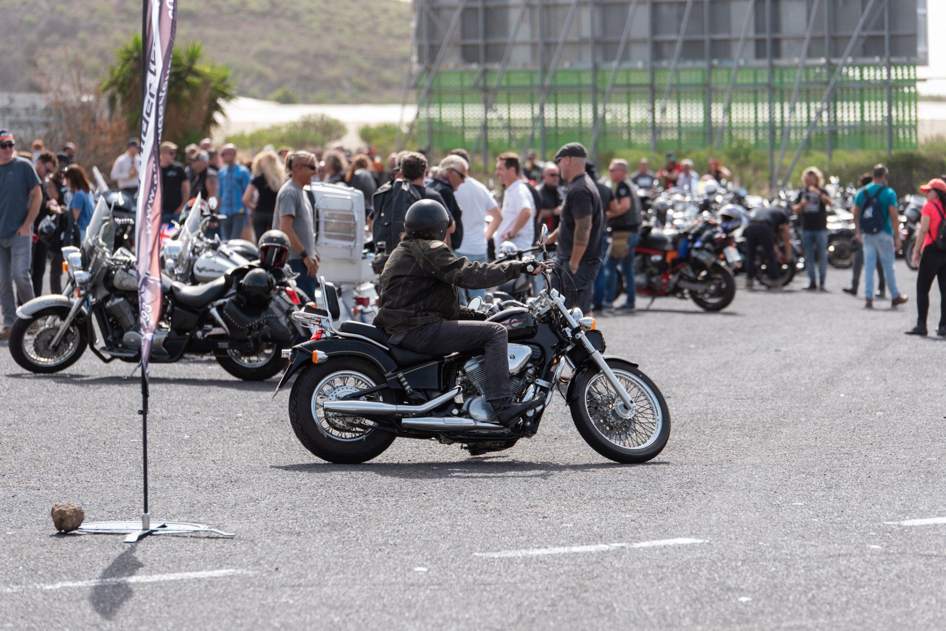 A man is riding a motorcycle in a parking lot