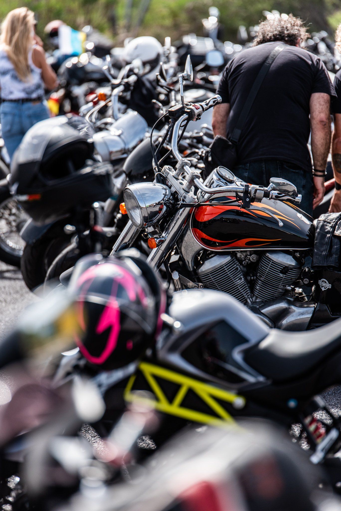 A man is standing in front of a row of motorcycles.