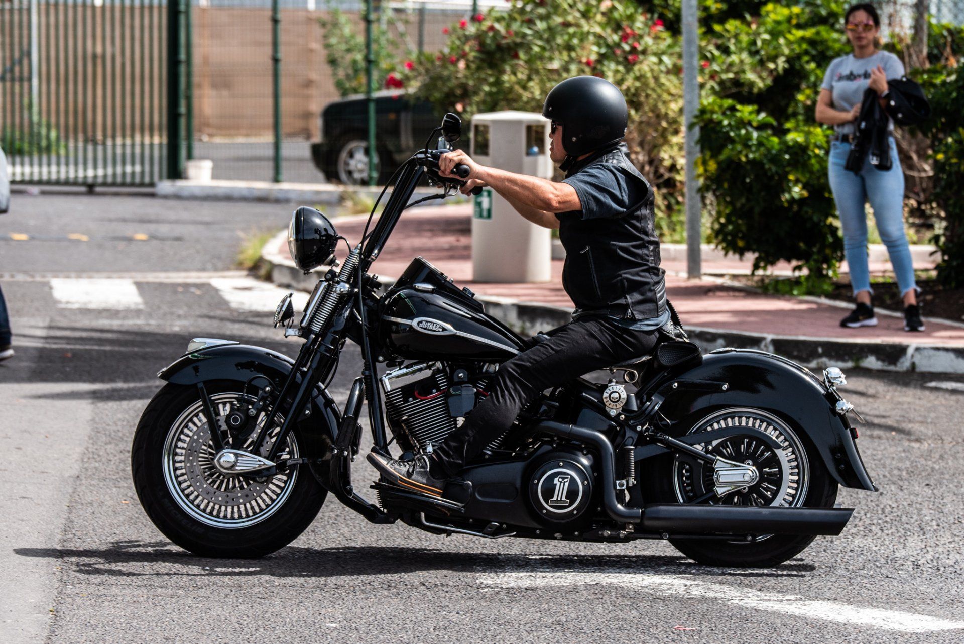 A man is riding a harley davidson motorcycle down a street.