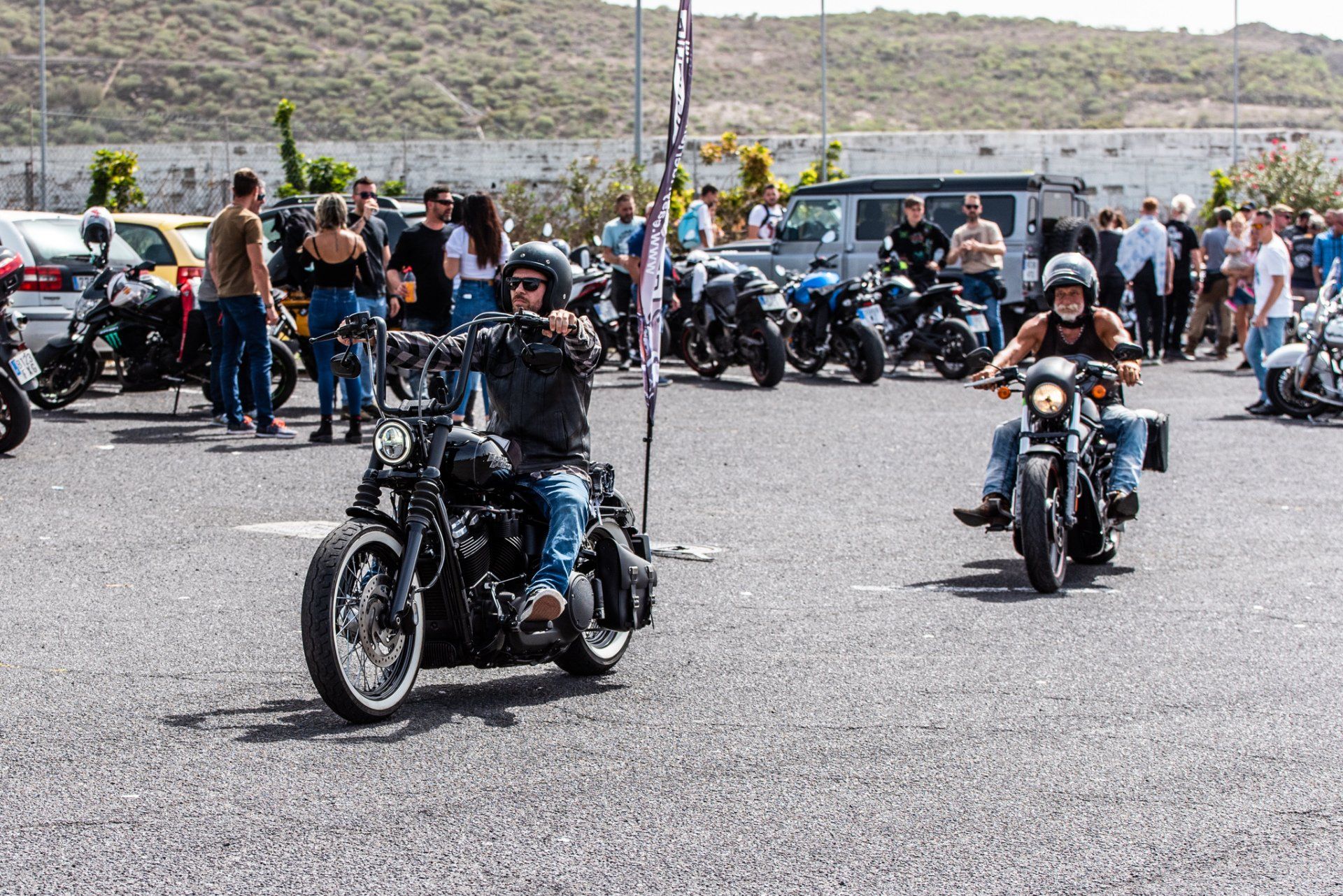 A group of people are riding motorcycles in a parking lot.