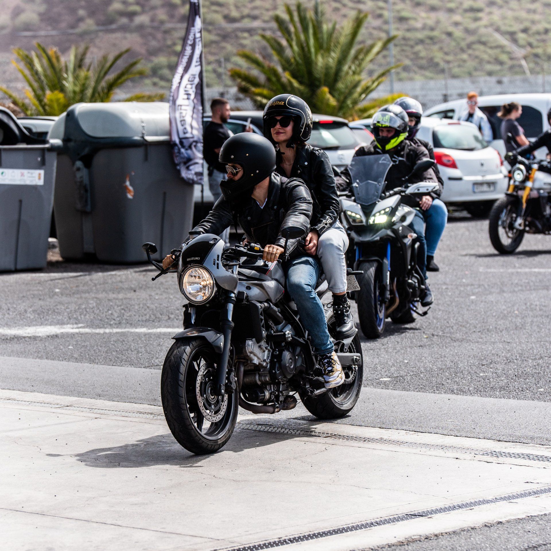 A group of people are riding motorcycles down a street
