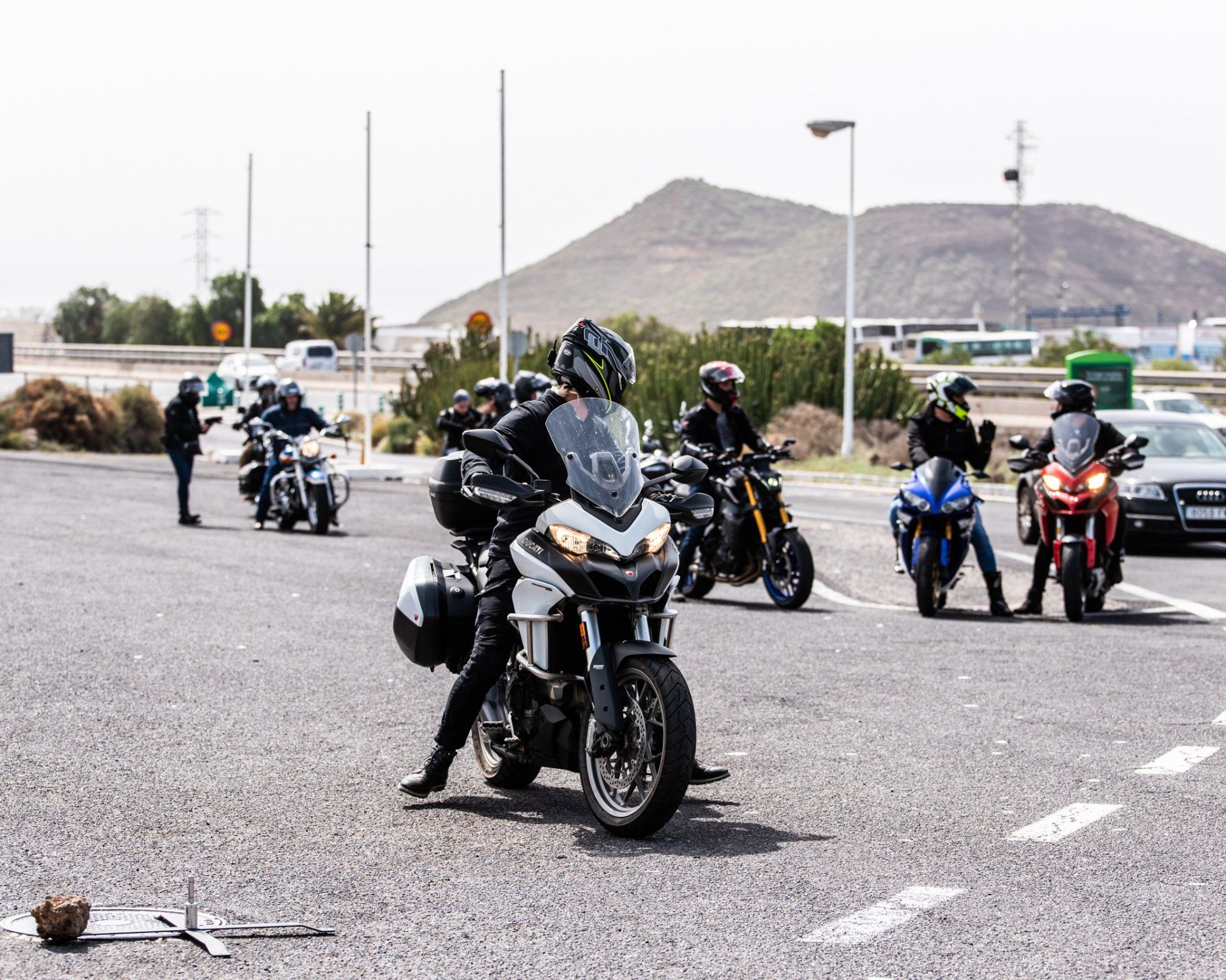 A group of people are riding motorcycles in a parking lot.
