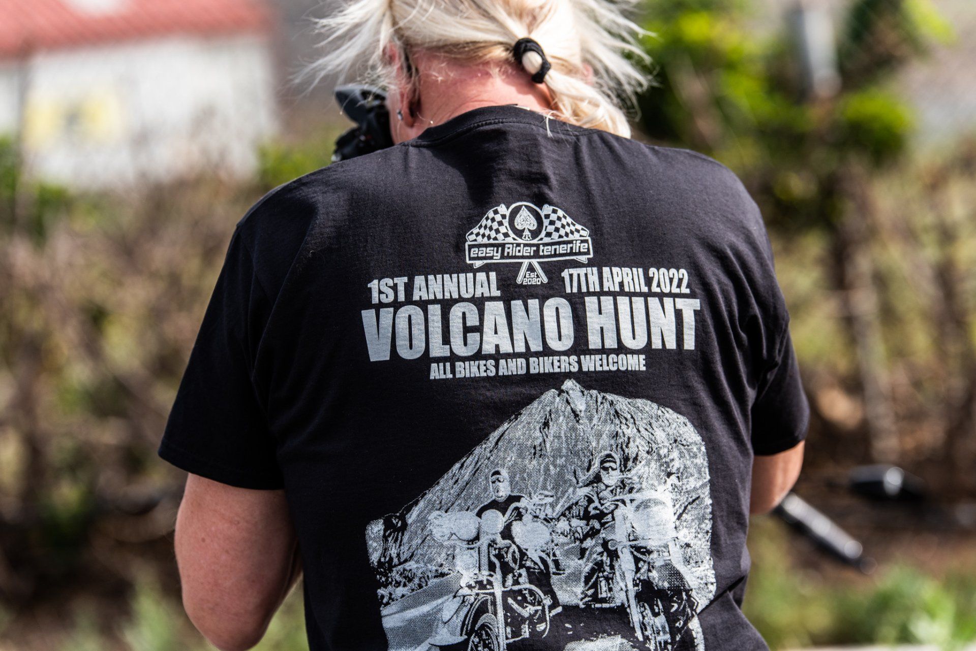 A woman is wearing a black t-shirt that says volcano hunt.