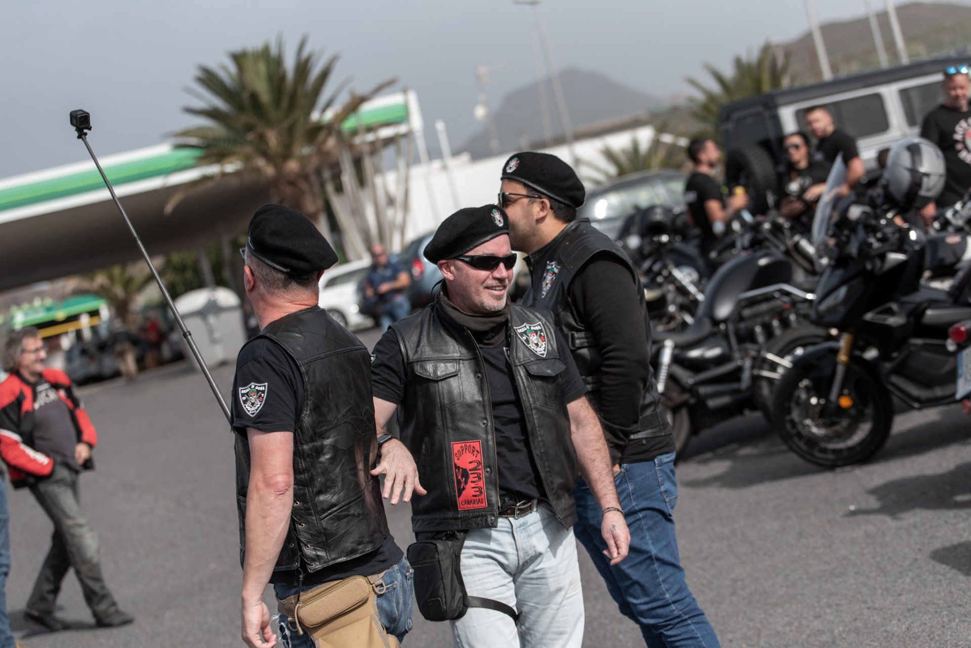 A group of men are standing in front of a row of motorcycles.