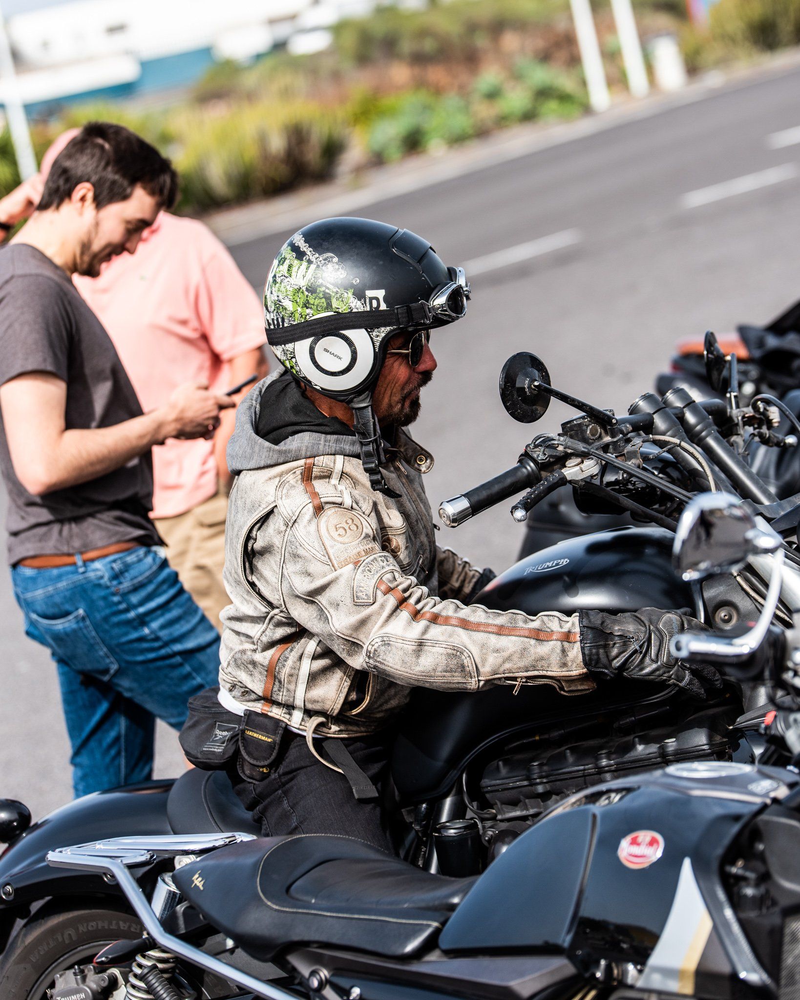 A man wearing a helmet is sitting on a motorcycle.