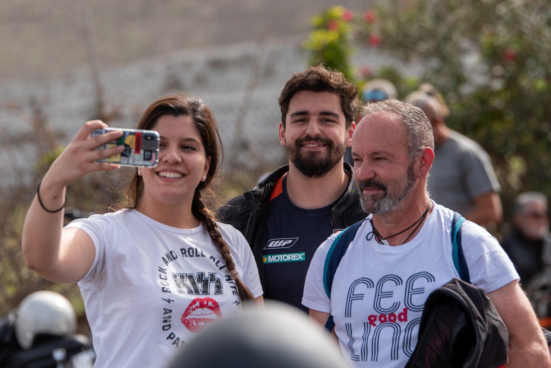 A woman is taking a selfie with two men.
