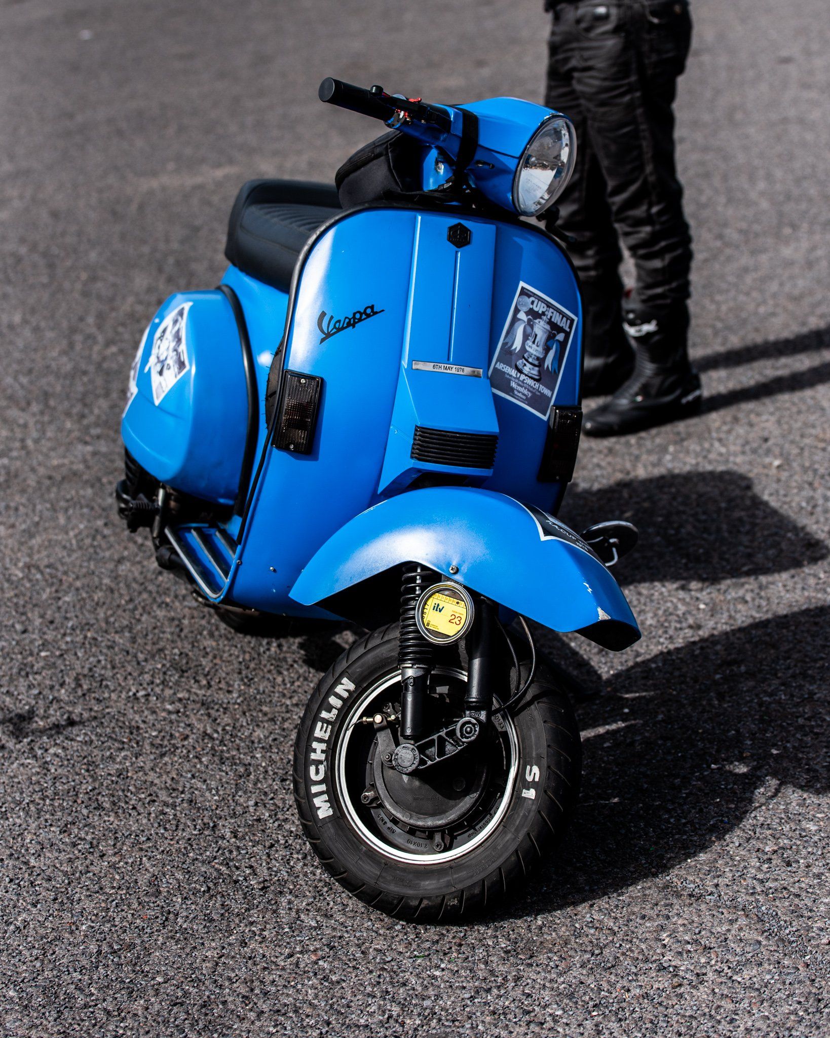 A blue scooter with michelin tires on it