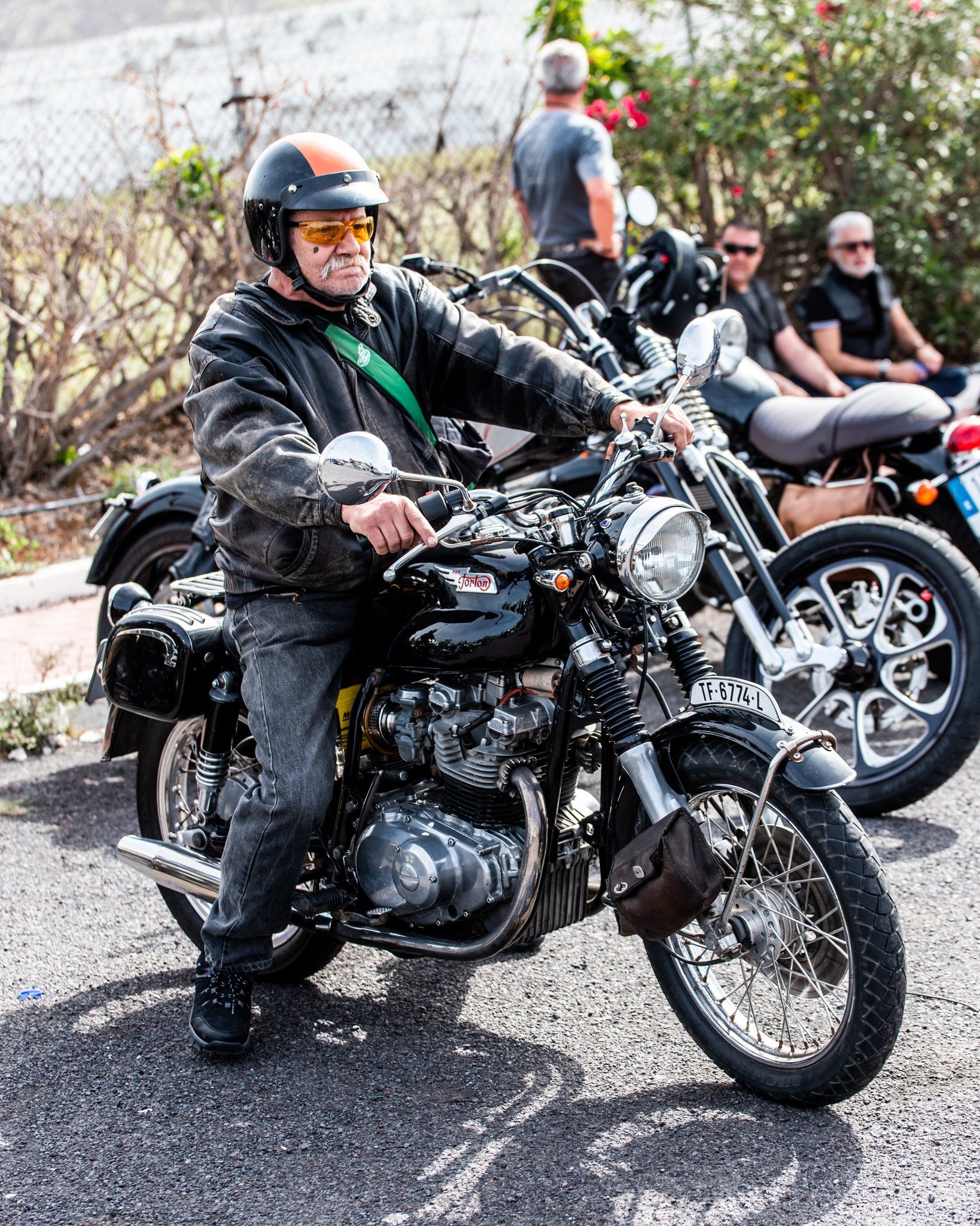 A man is riding a motorcycle down a street.