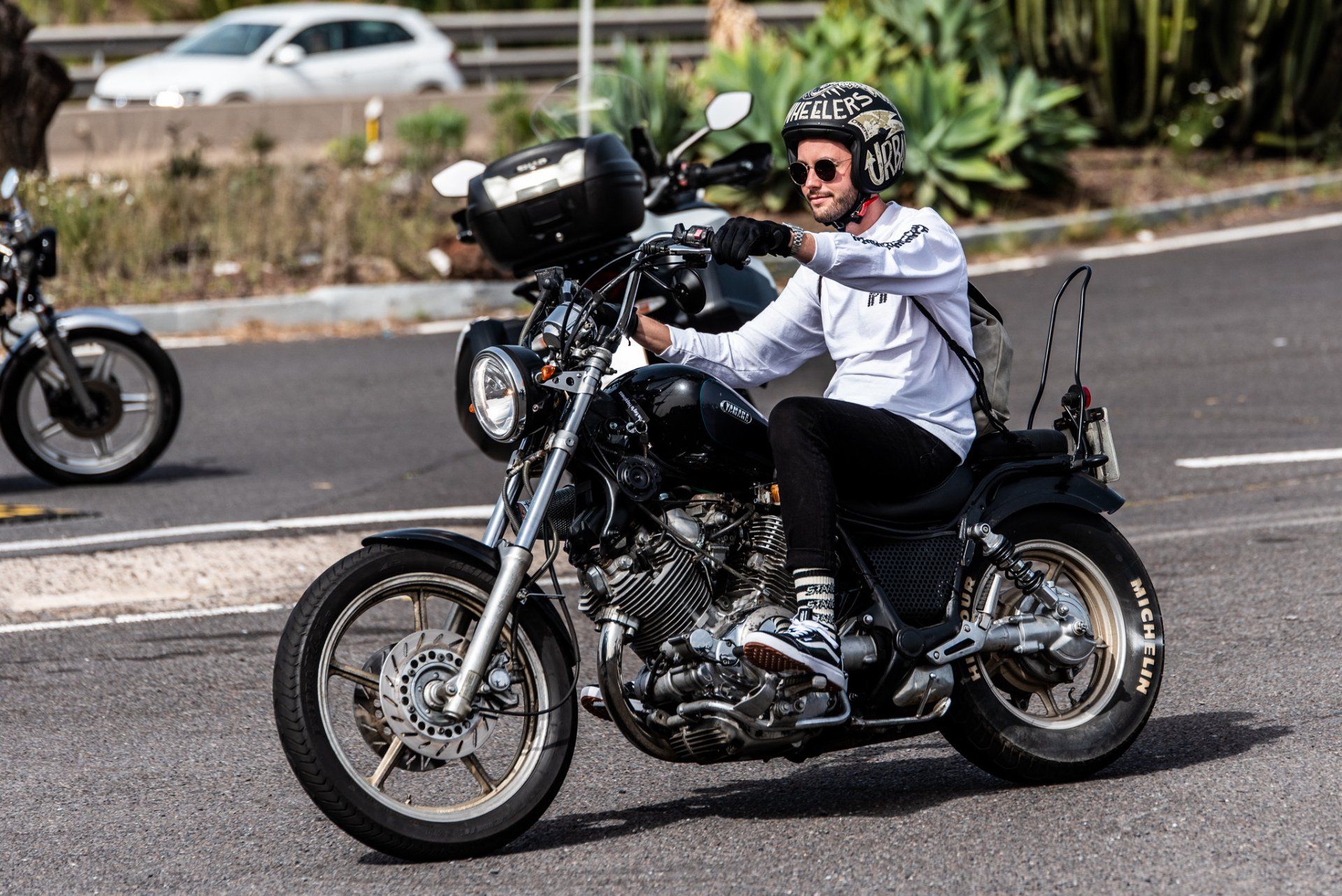 A man is riding a motorcycle down a road.