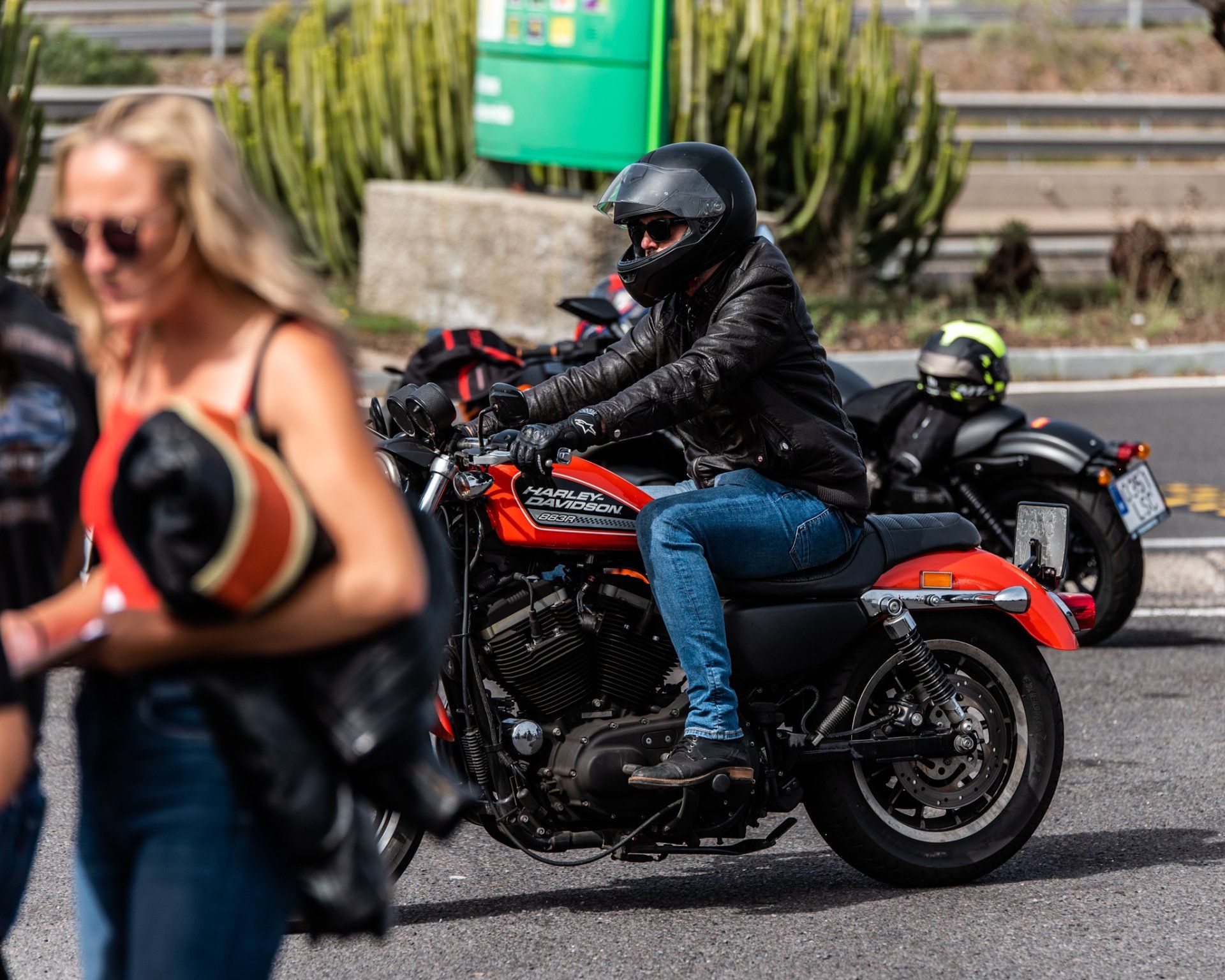A man is riding a harley davidson motorcycle down a street.