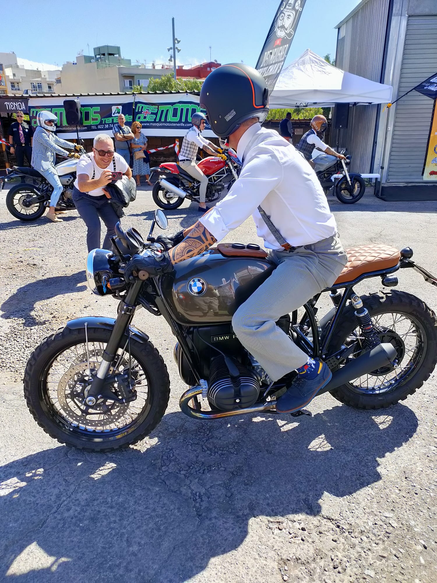 A man is riding a motorcycle in a parking lot.