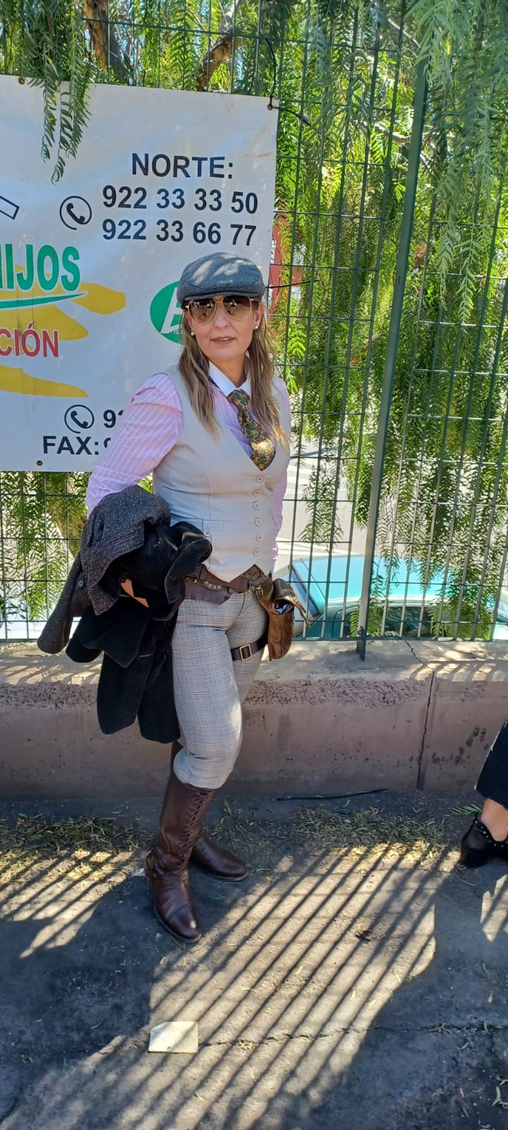 A woman is standing next to a sign holding two dogs.