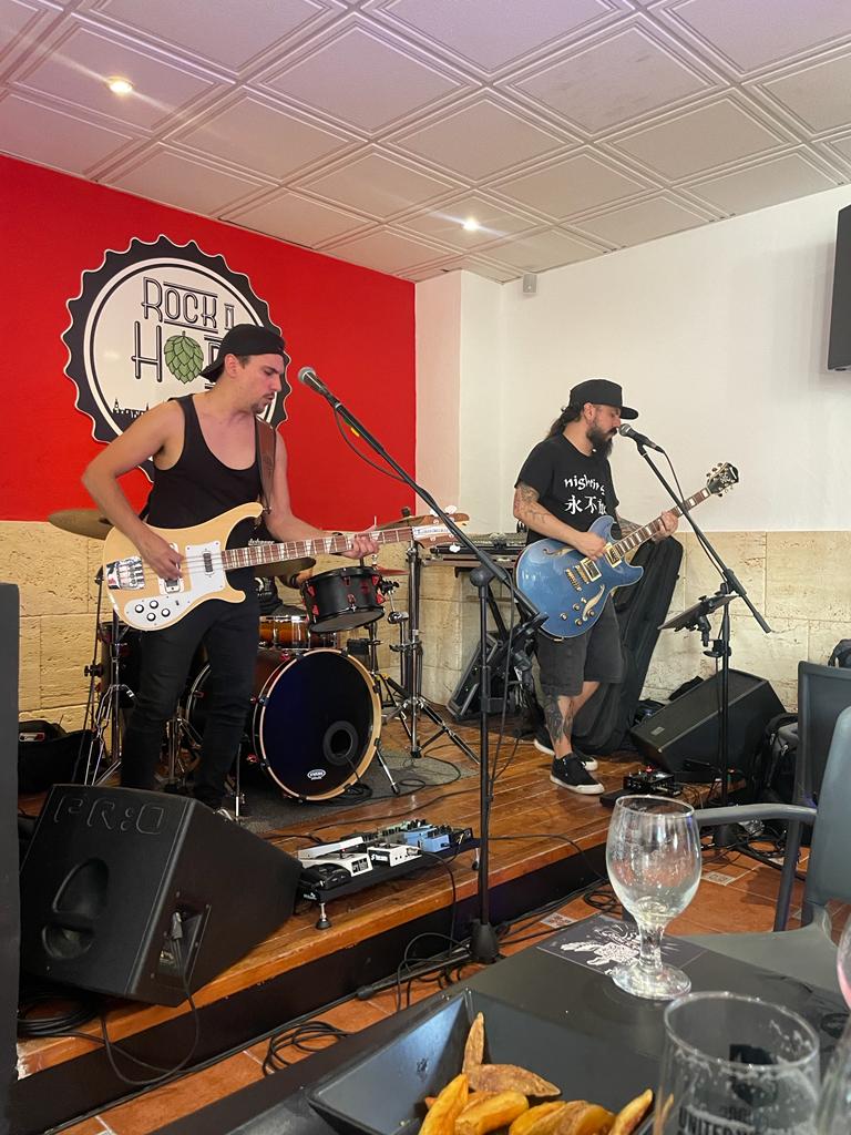 A man is playing a guitar and a woman is singing into a microphone.