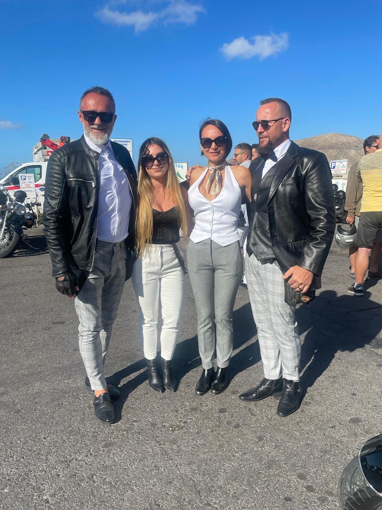 A group of people are posing for a picture in a parking lot.