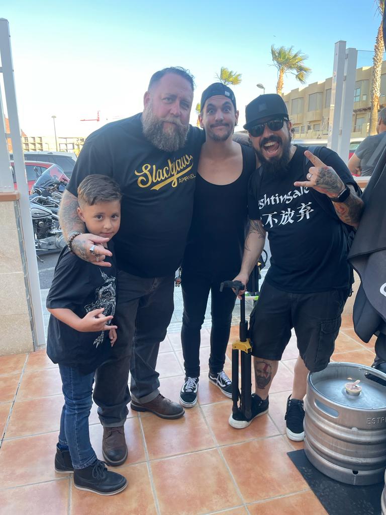 A group of men are posing for a picture with a little boy.