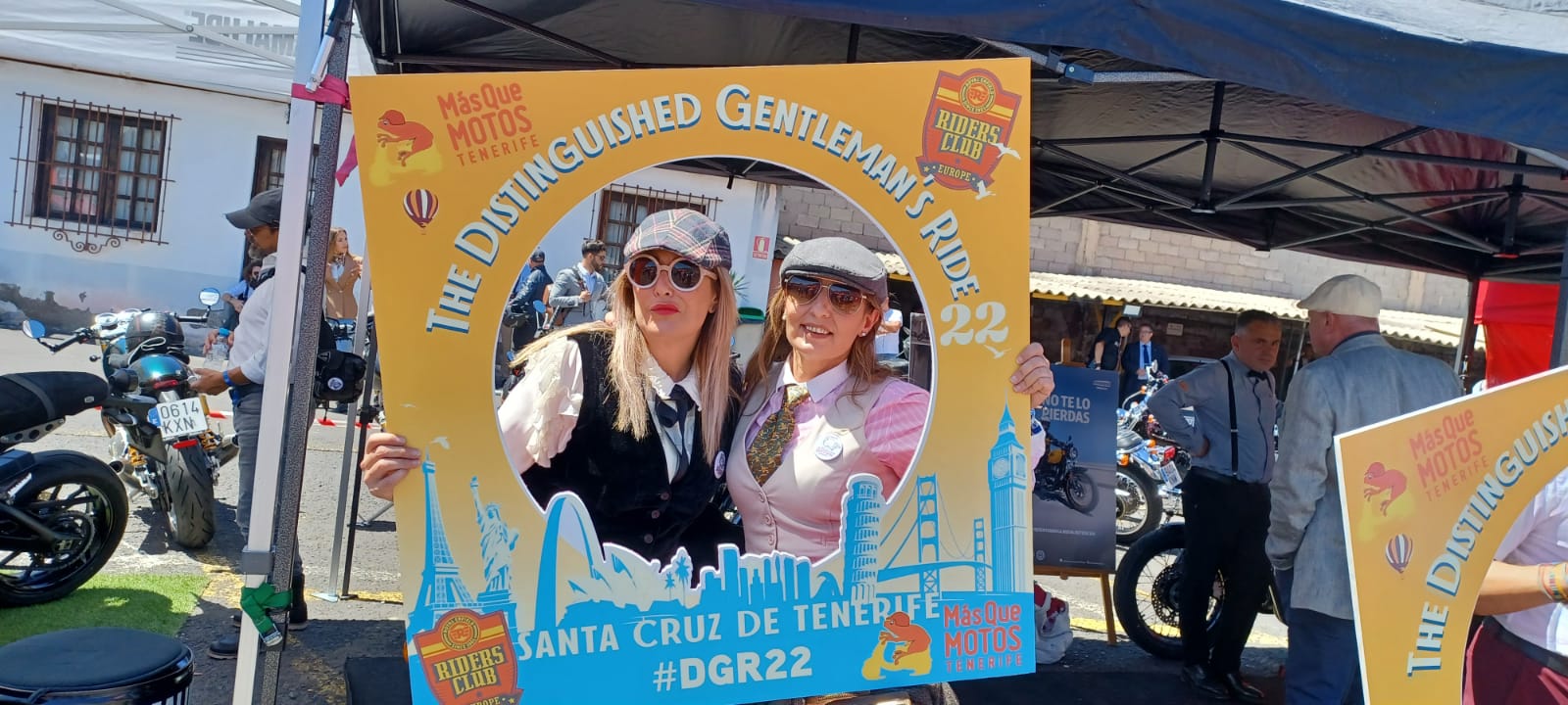 Two women are posing for a picture in front of a sign that says santa cruz