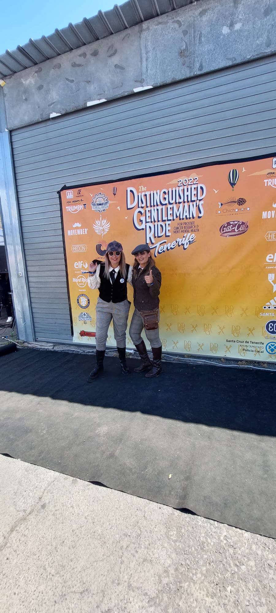 Two people are standing in front of a building with a sign that says ' cowboys and indians ' on it.