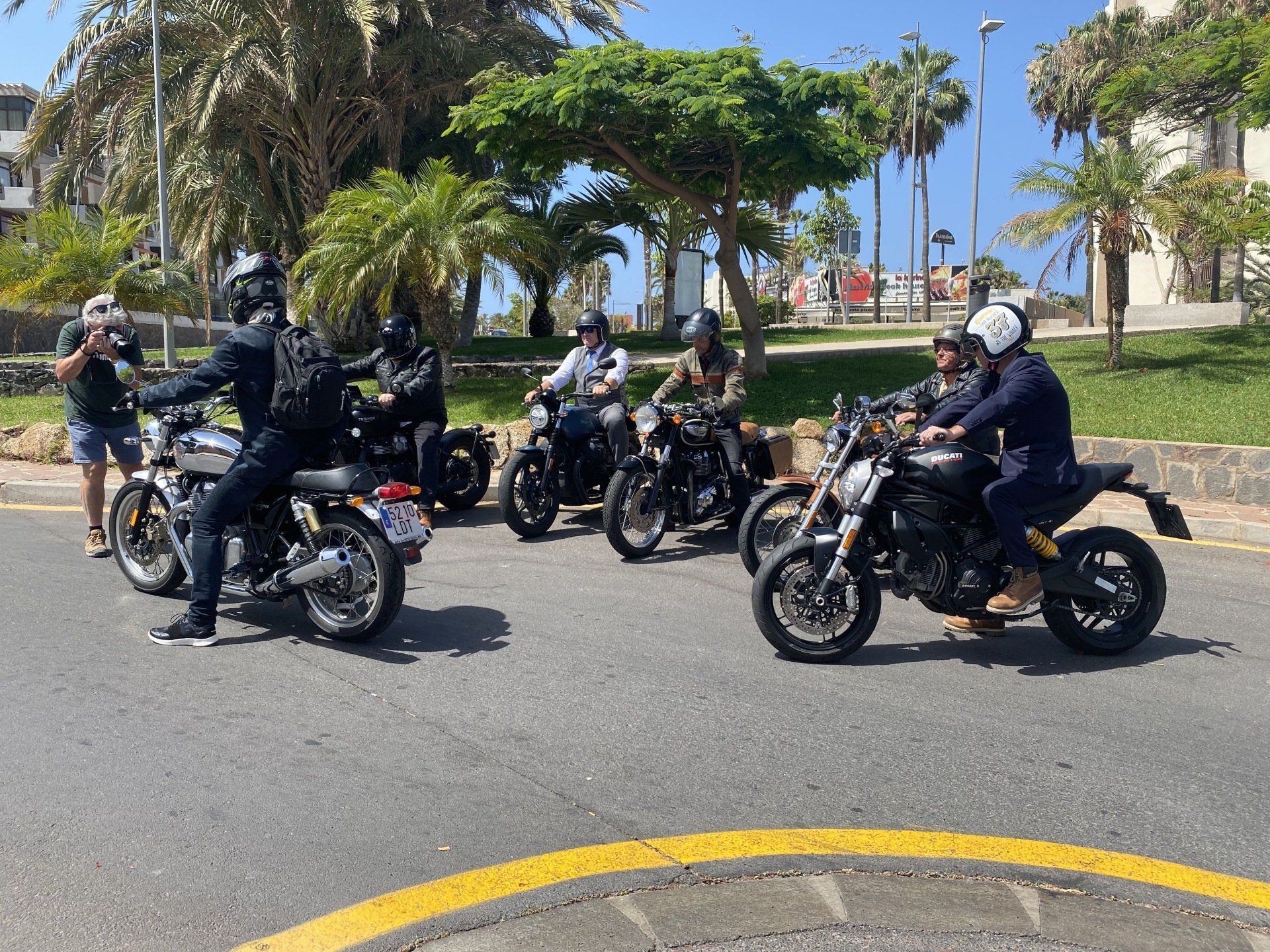 A group of people are riding motorcycles down a street.