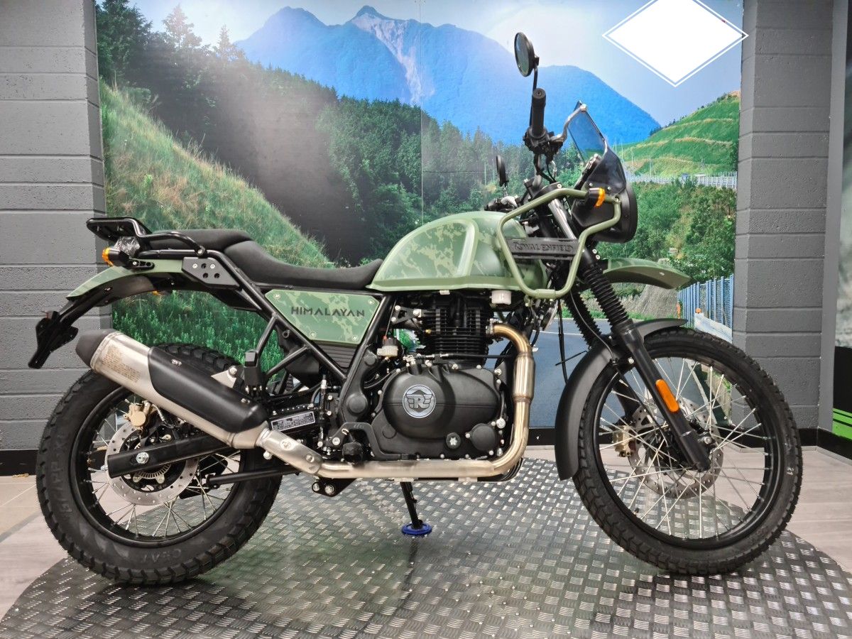 A motorcycle is sitting on top of a metal floor in a showroom.