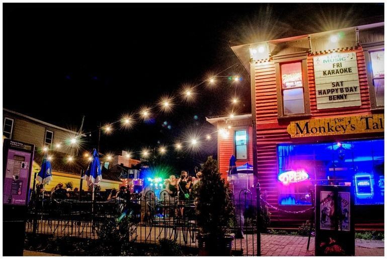 A group of people are sitting outside of a restaurant at night.