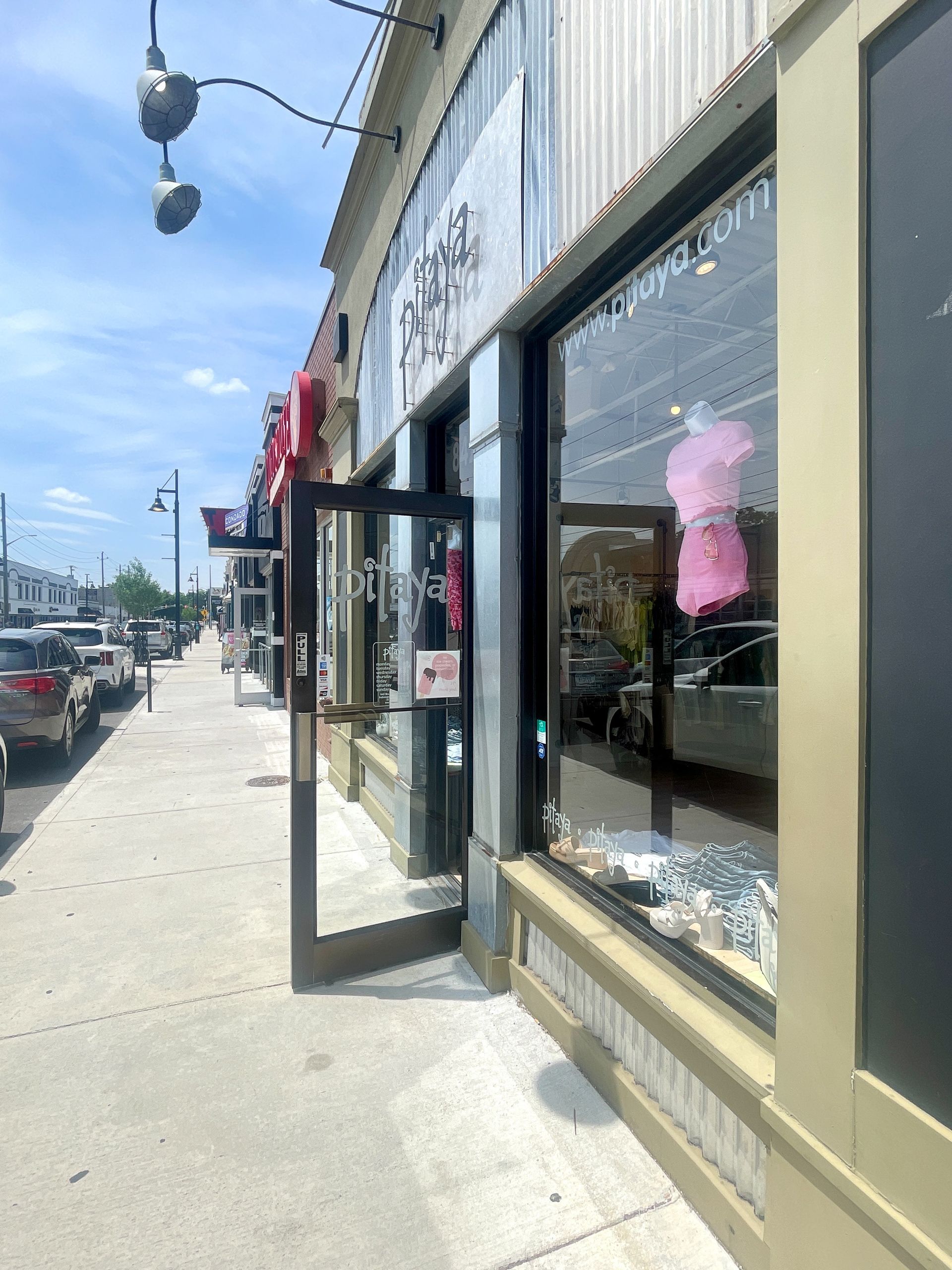 A store front with a pink shirt in the window