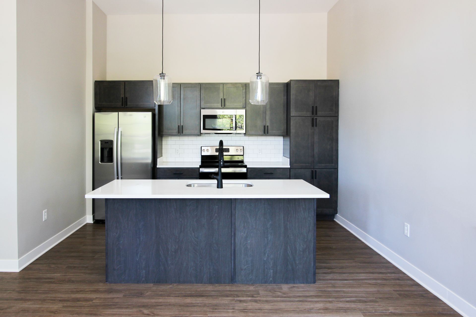 A kitchen with a large island and stainless steel appliances.