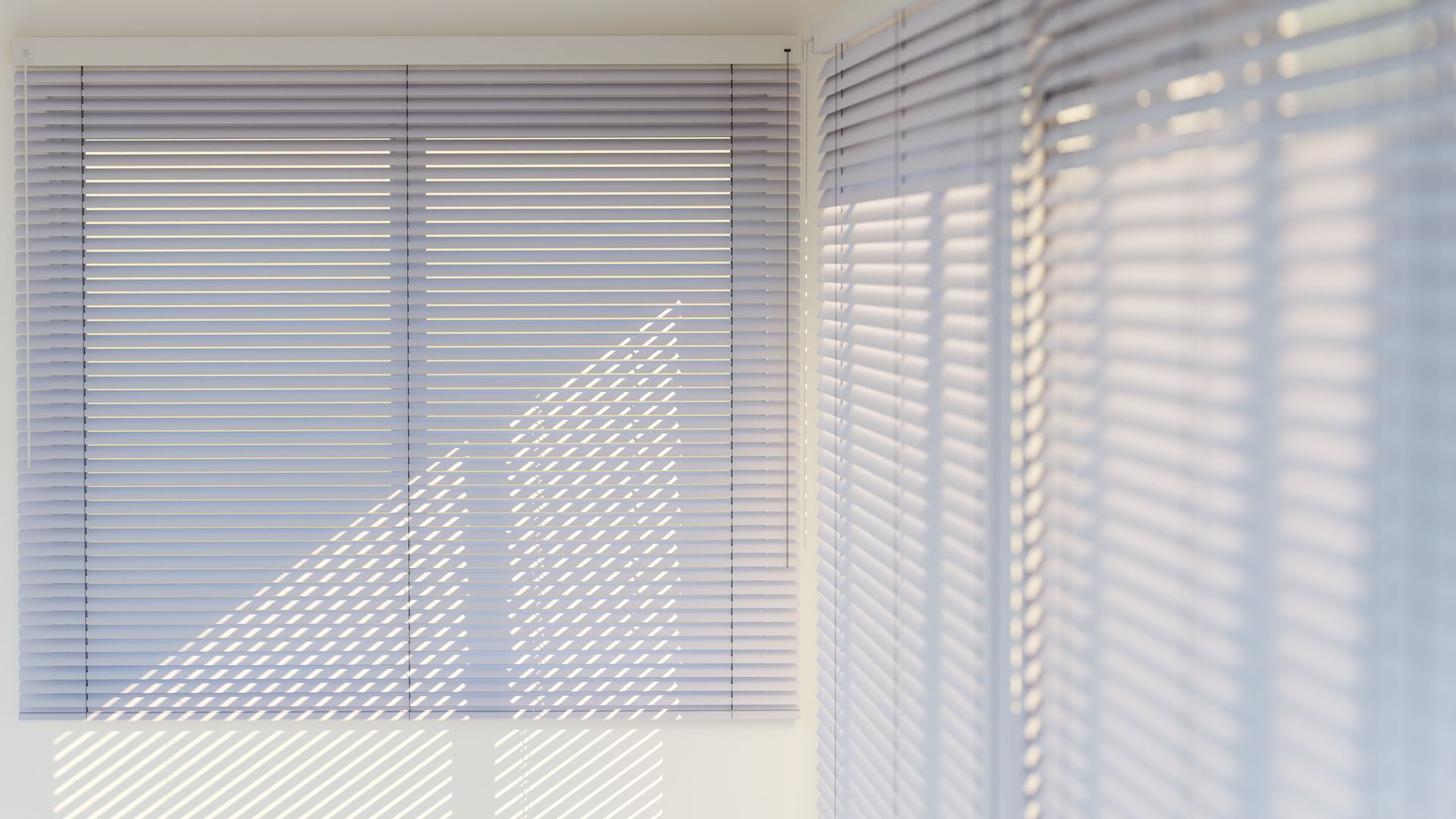 Interior room view with white venetian blinds filtering sunlight and creating soft shadow patterns.