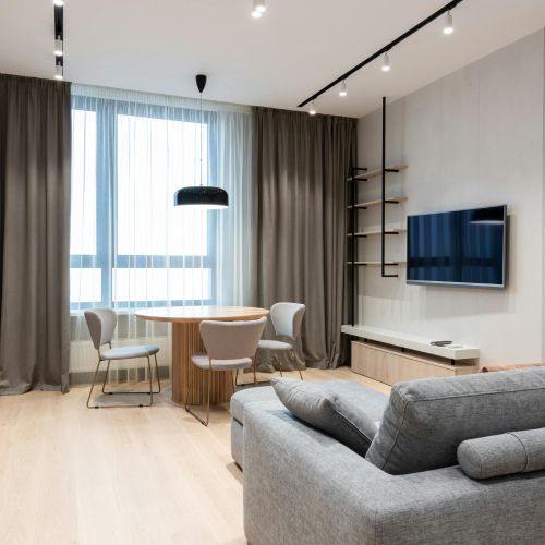 A living room with a couch , chairs , table and television.