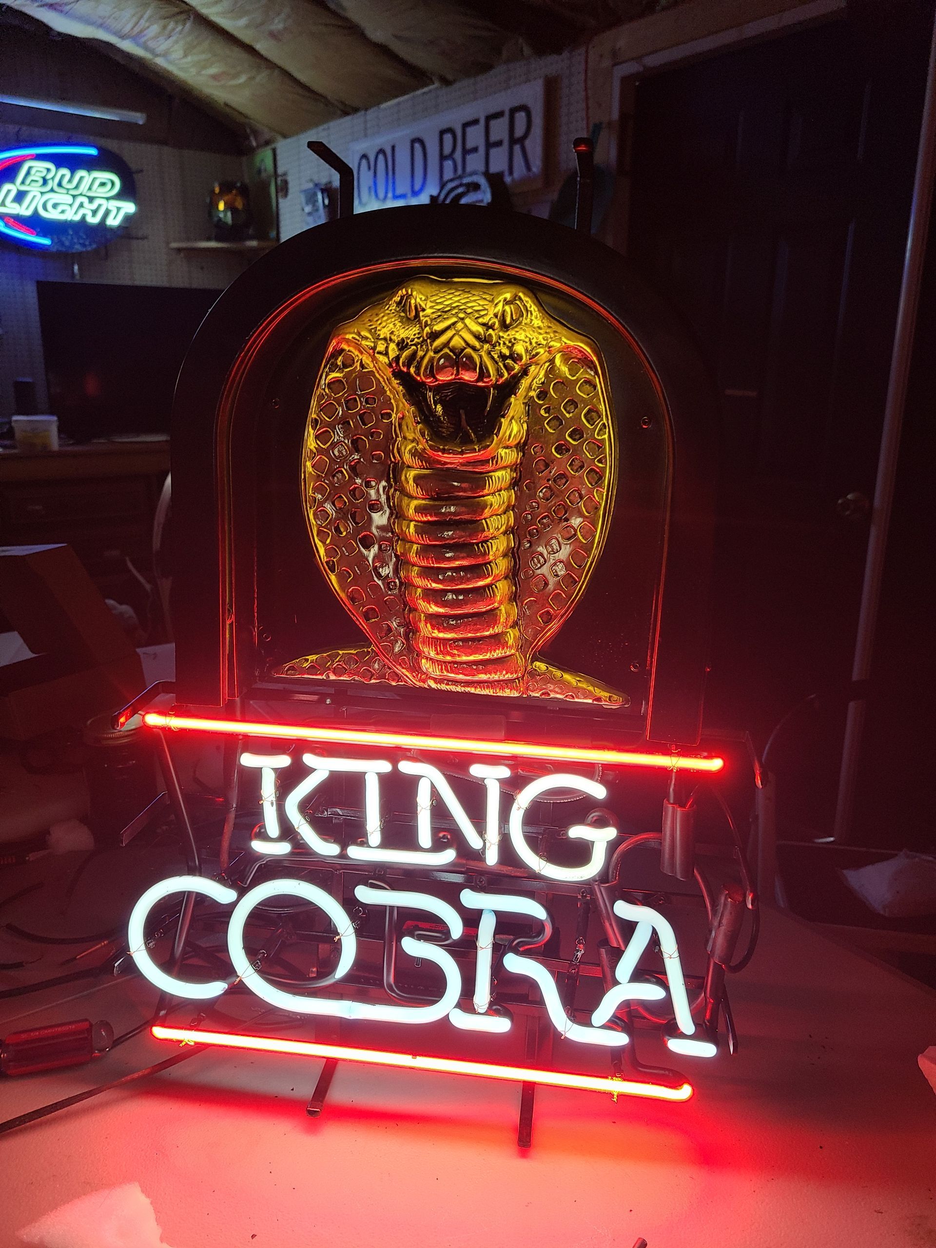 Neon sign: King Cobra beer logo with a glowing cobra and text in red and white.