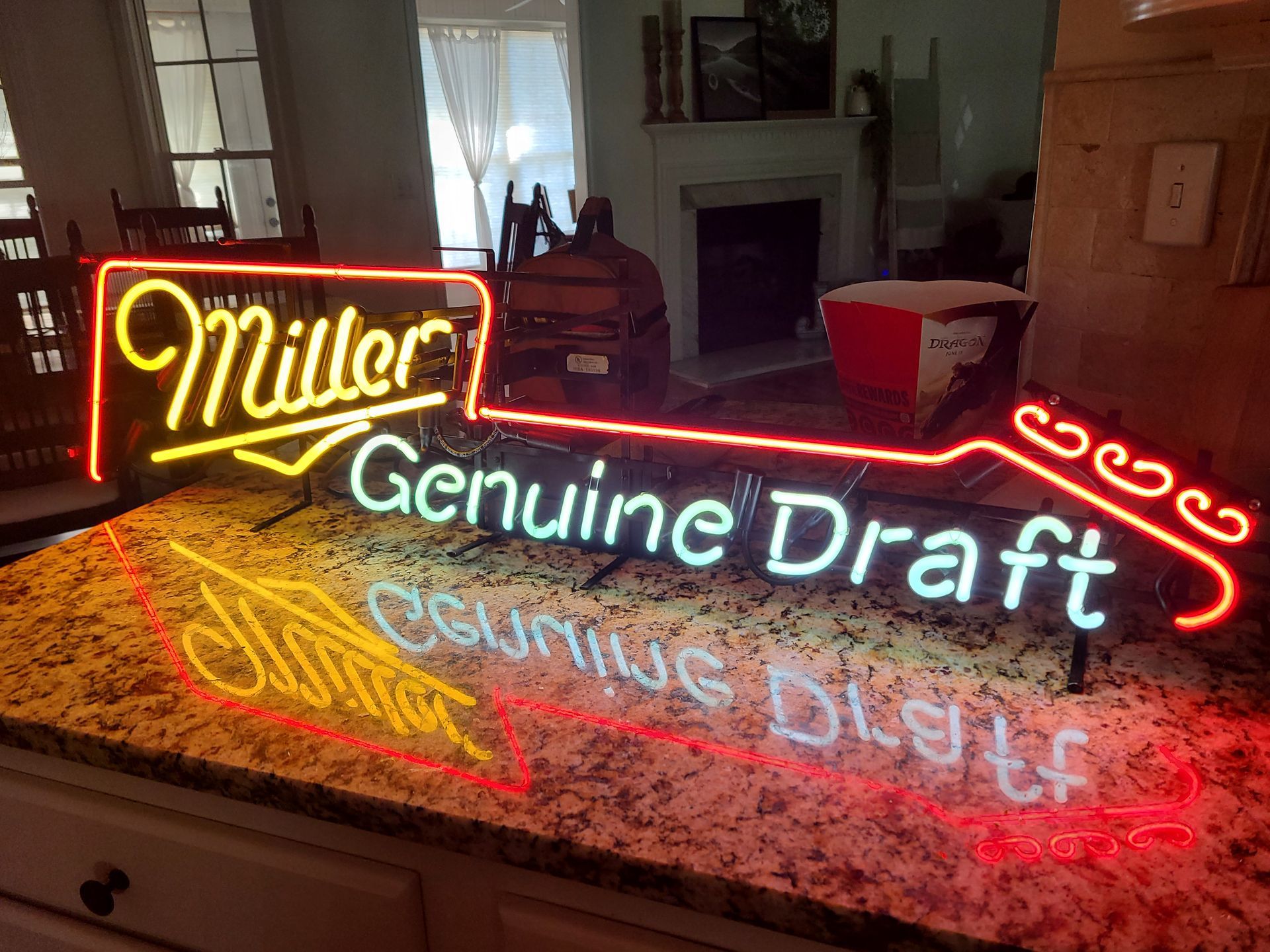 Neon Miller Genuine Draft sign on a countertop, reflecting light.