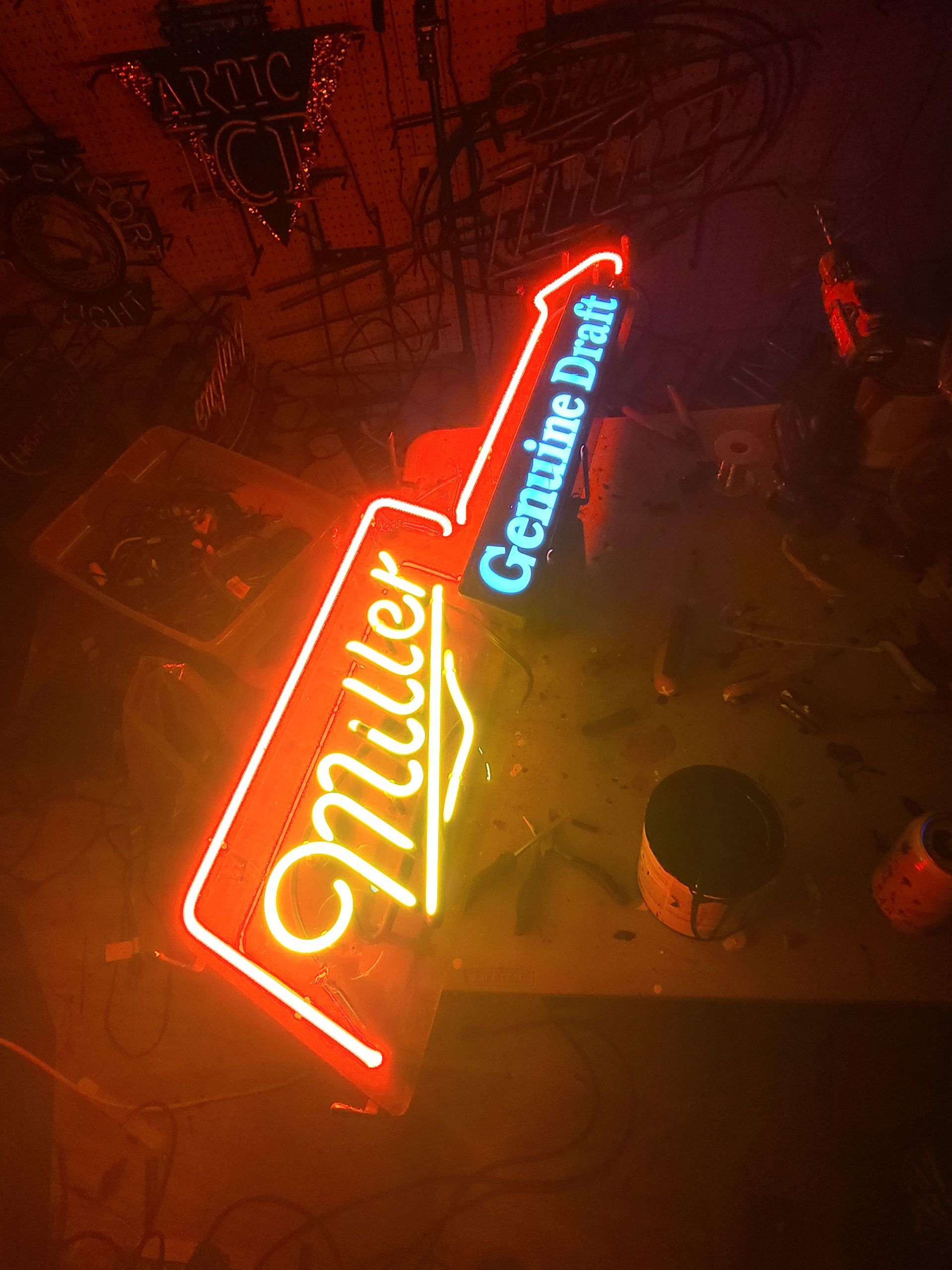 Neon Miller Genuine Draft beer sign, red and yellow lettering, blue text.