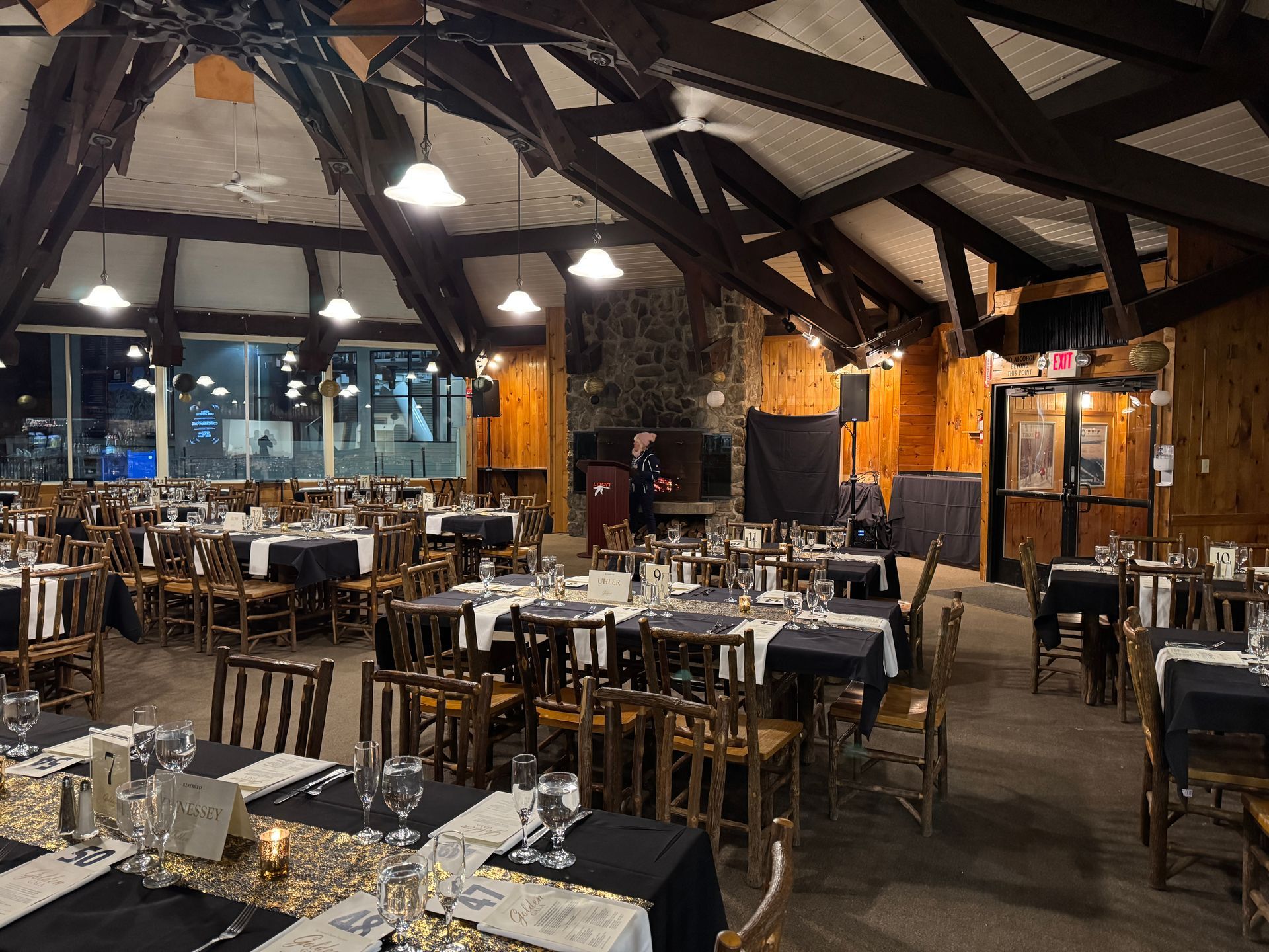 Interior of a banquet hall, tables set with black and white linens.