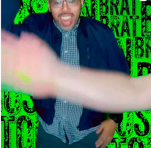 Man in glasses and jacket, open mouth, arm blurred forward against a green background with text.