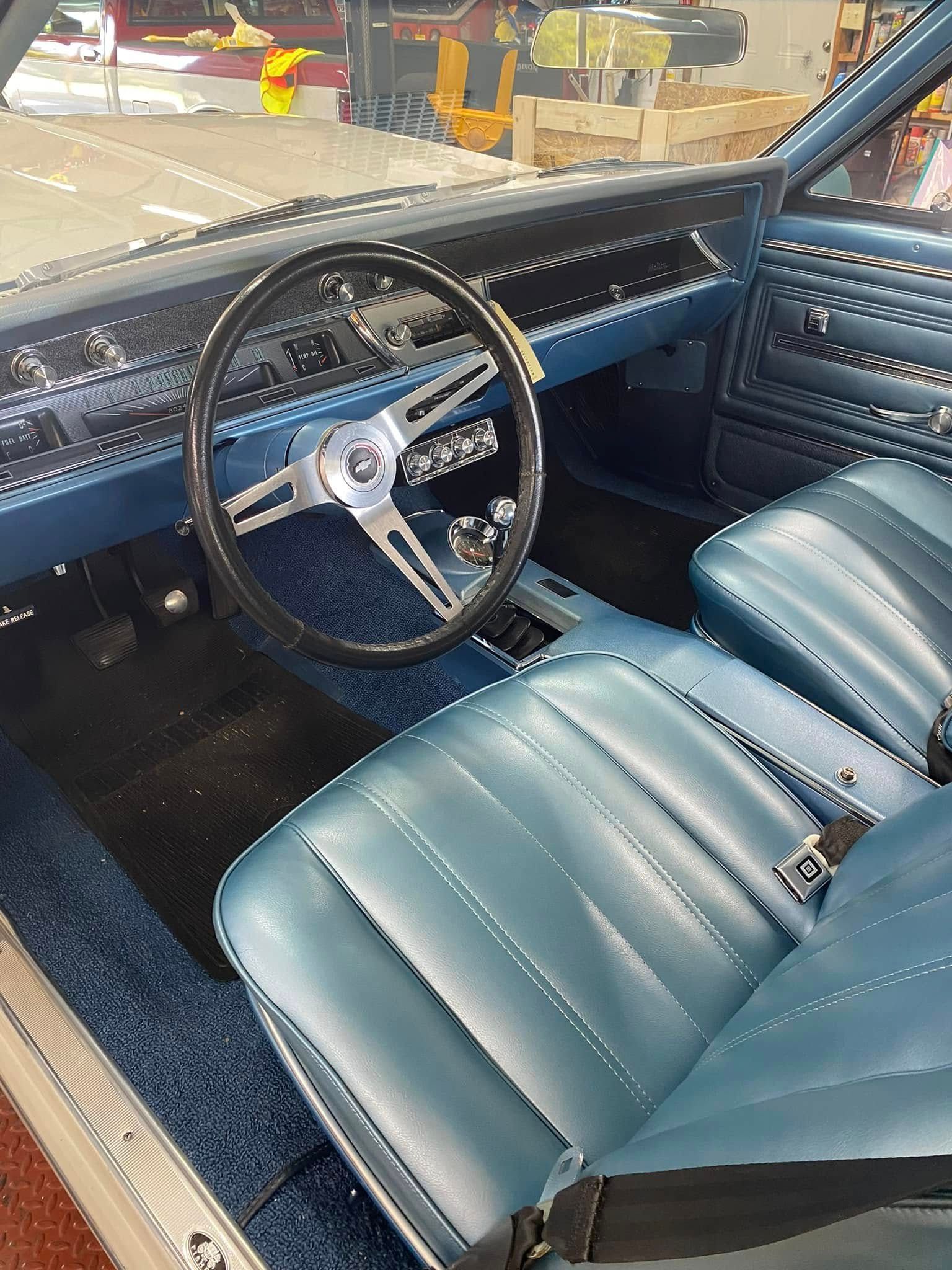 The interior of a car with blue seats and a steering wheel.