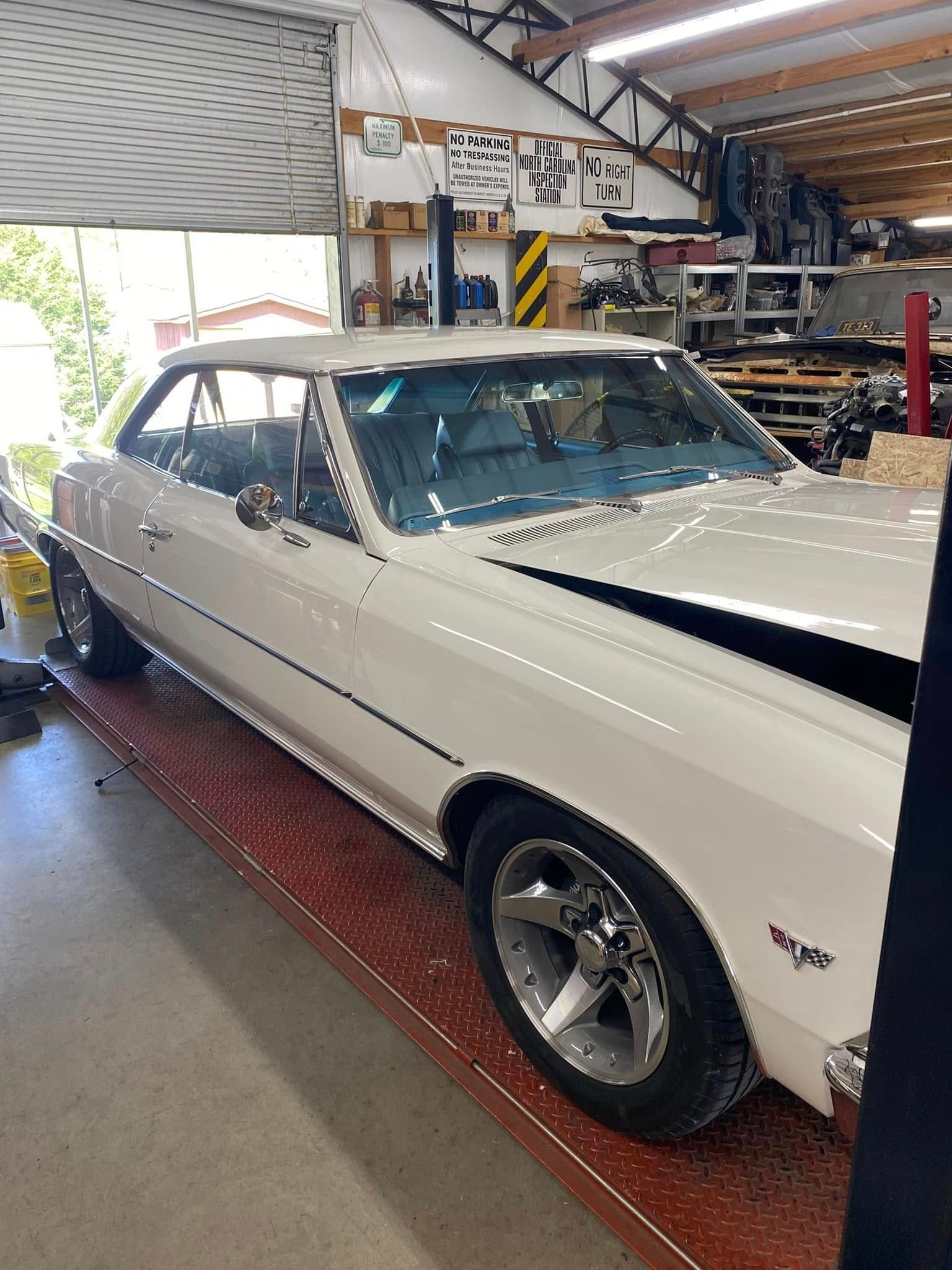 A white car is parked in a garage.