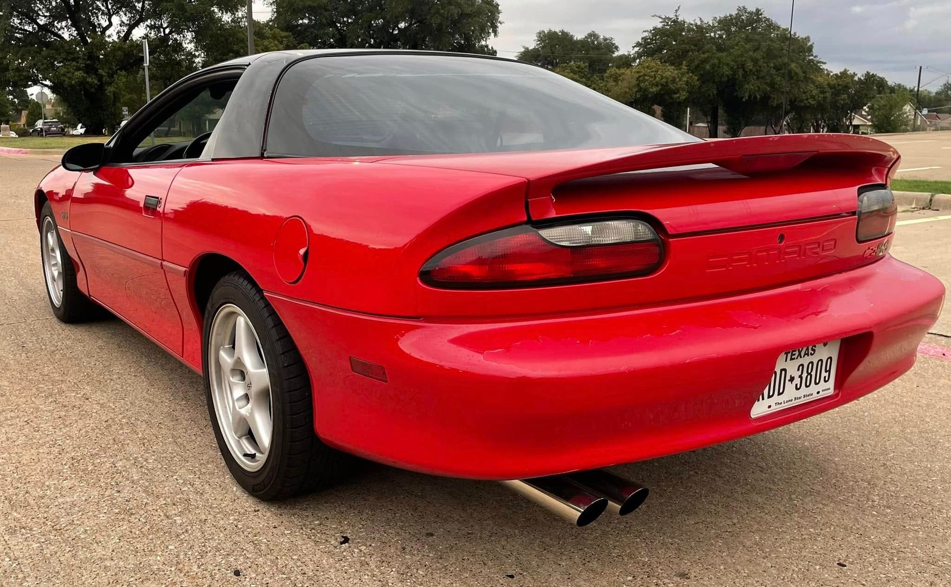 A red car is parked on the side of the road.
