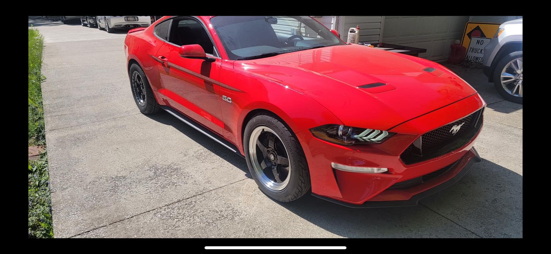 A red ford mustang is parked in a parking lot.