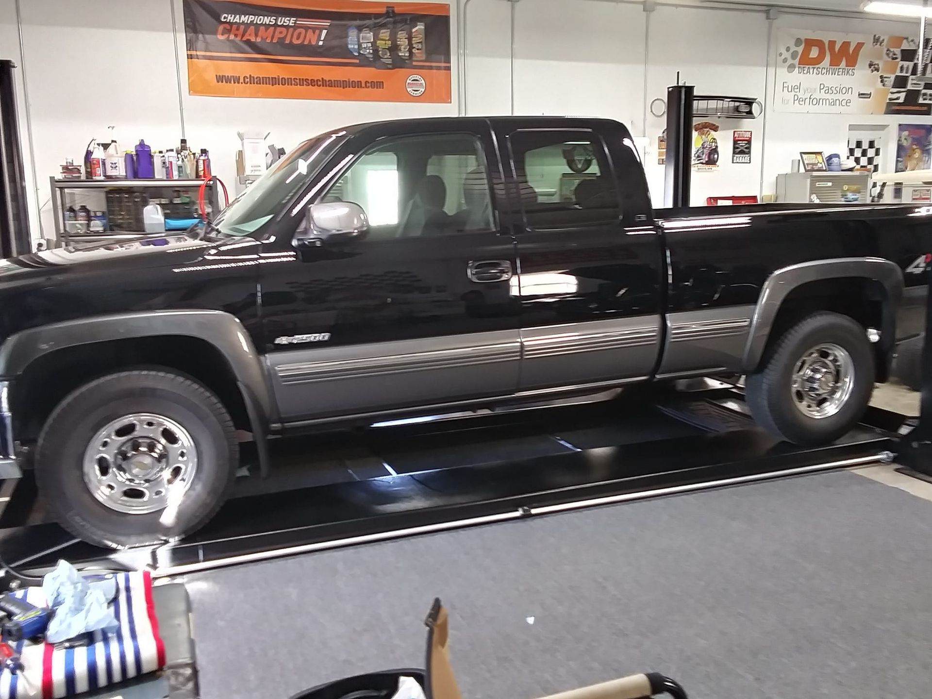 A black truck is sitting on a lift in a garage