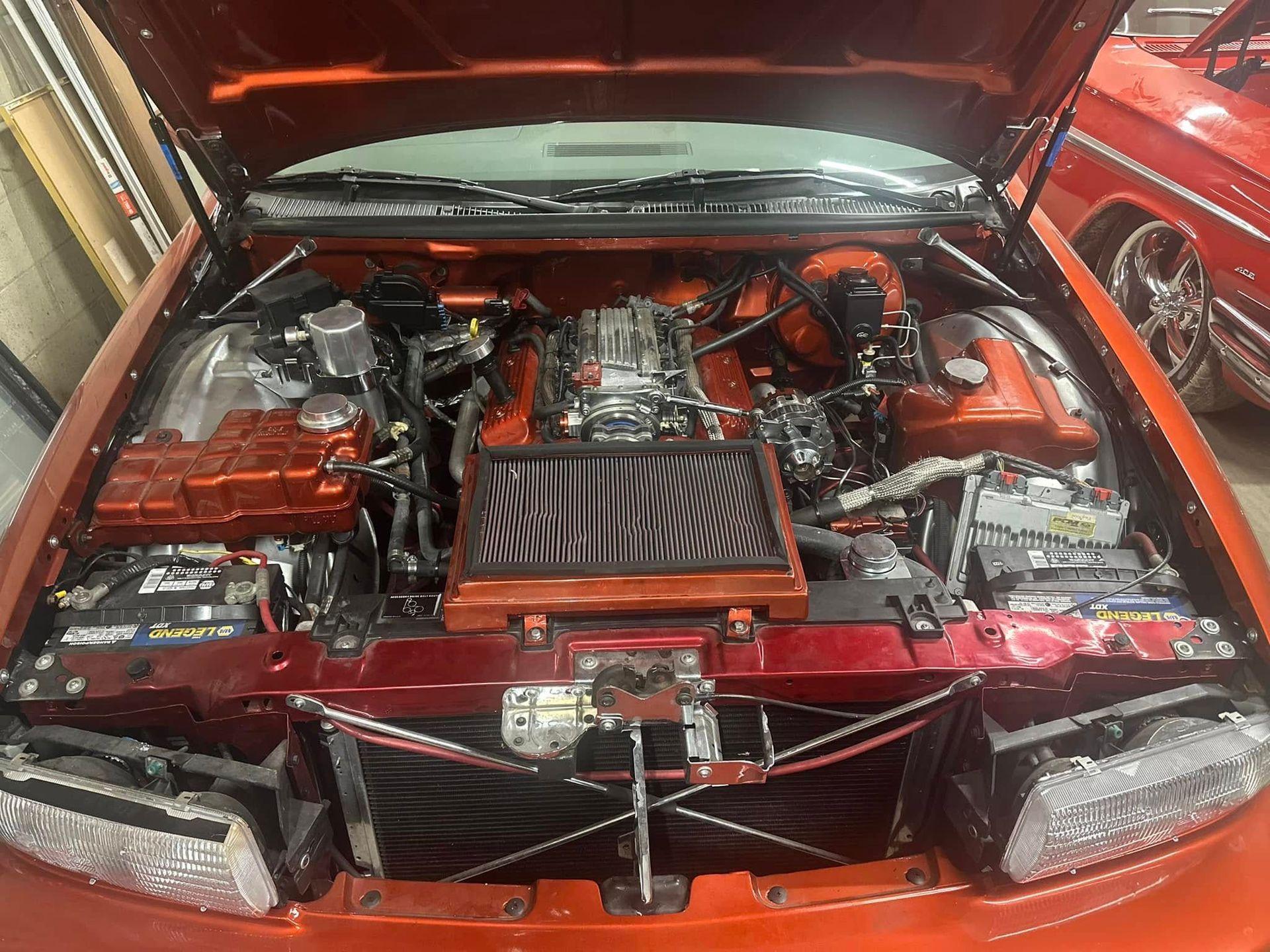 A close up of a car engine with the hood open.