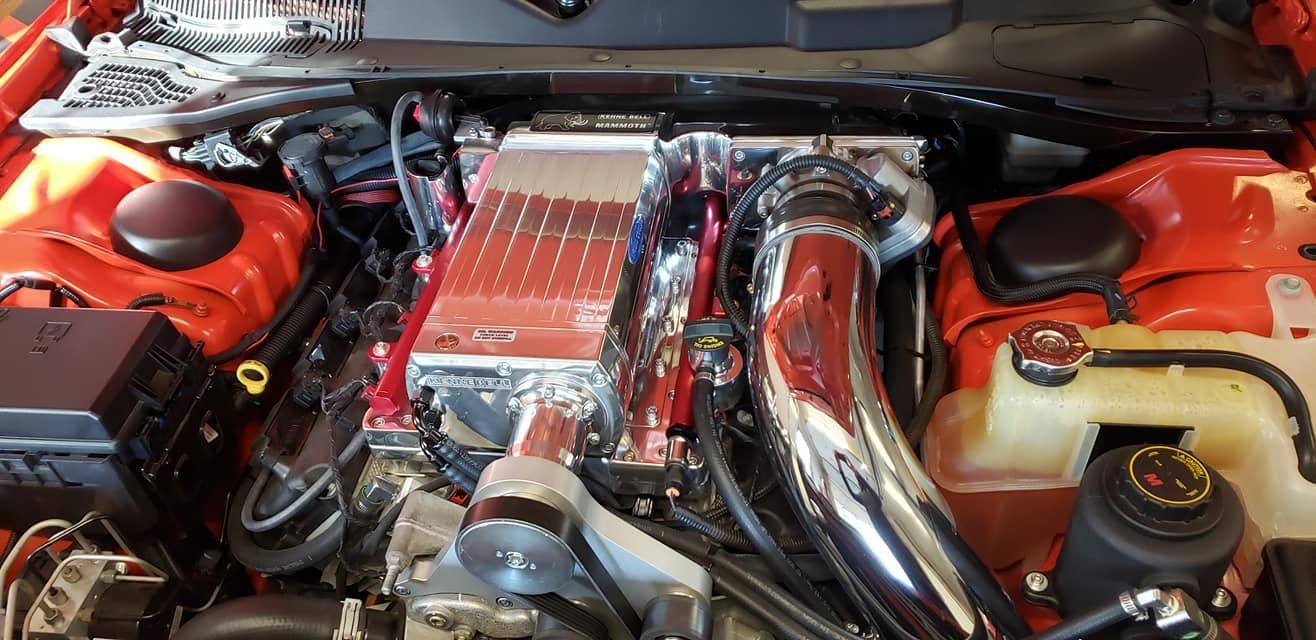 A close up of the engine of an orange car.